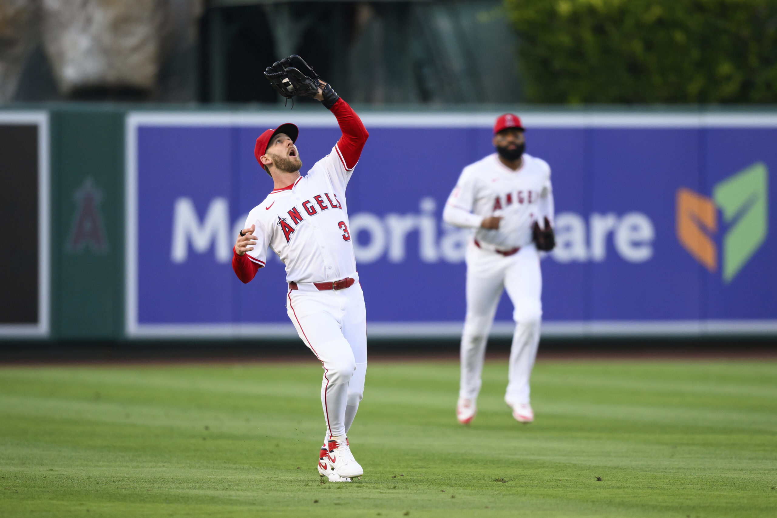 Angels left fielder Taylor Ward, left, makes a catch during...