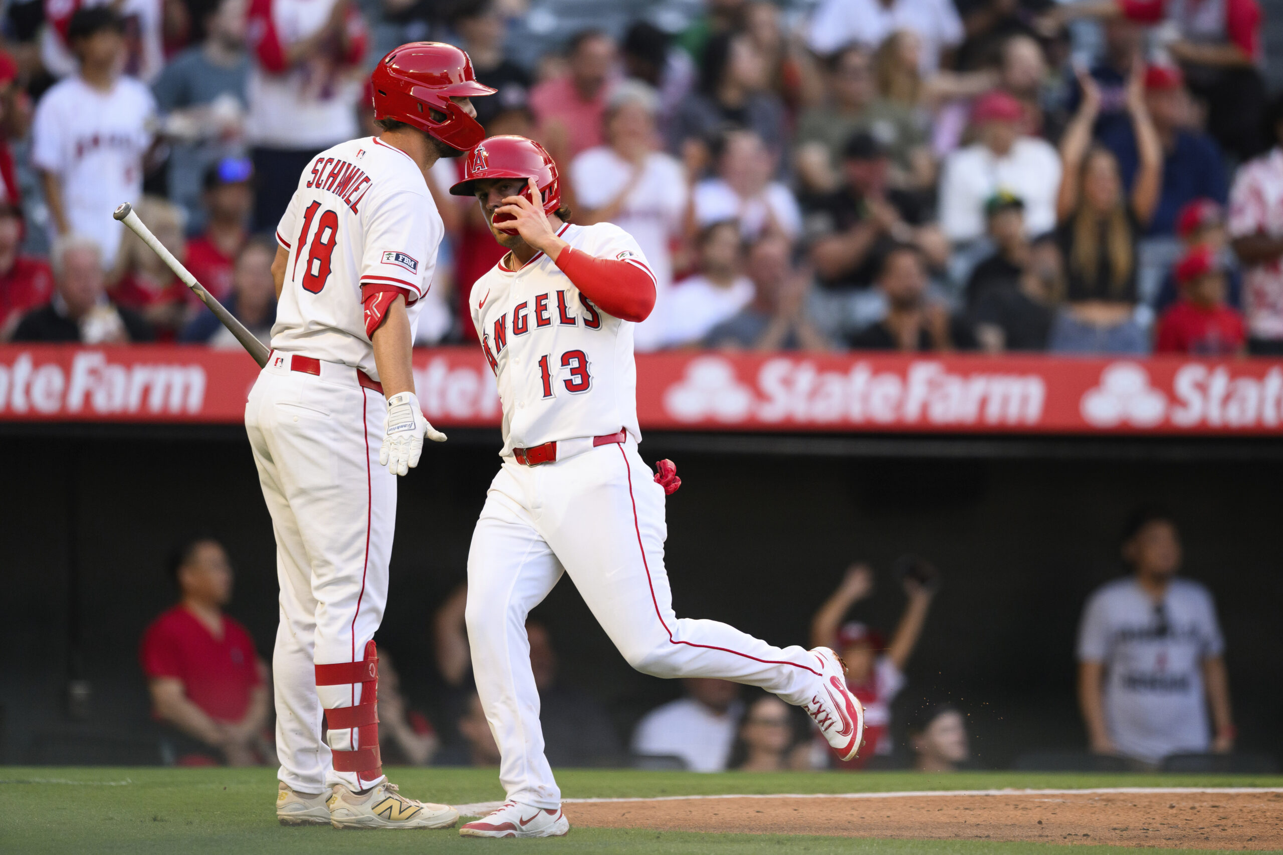 The Angels’ Scott Kingery, right, looks on after scoring during...