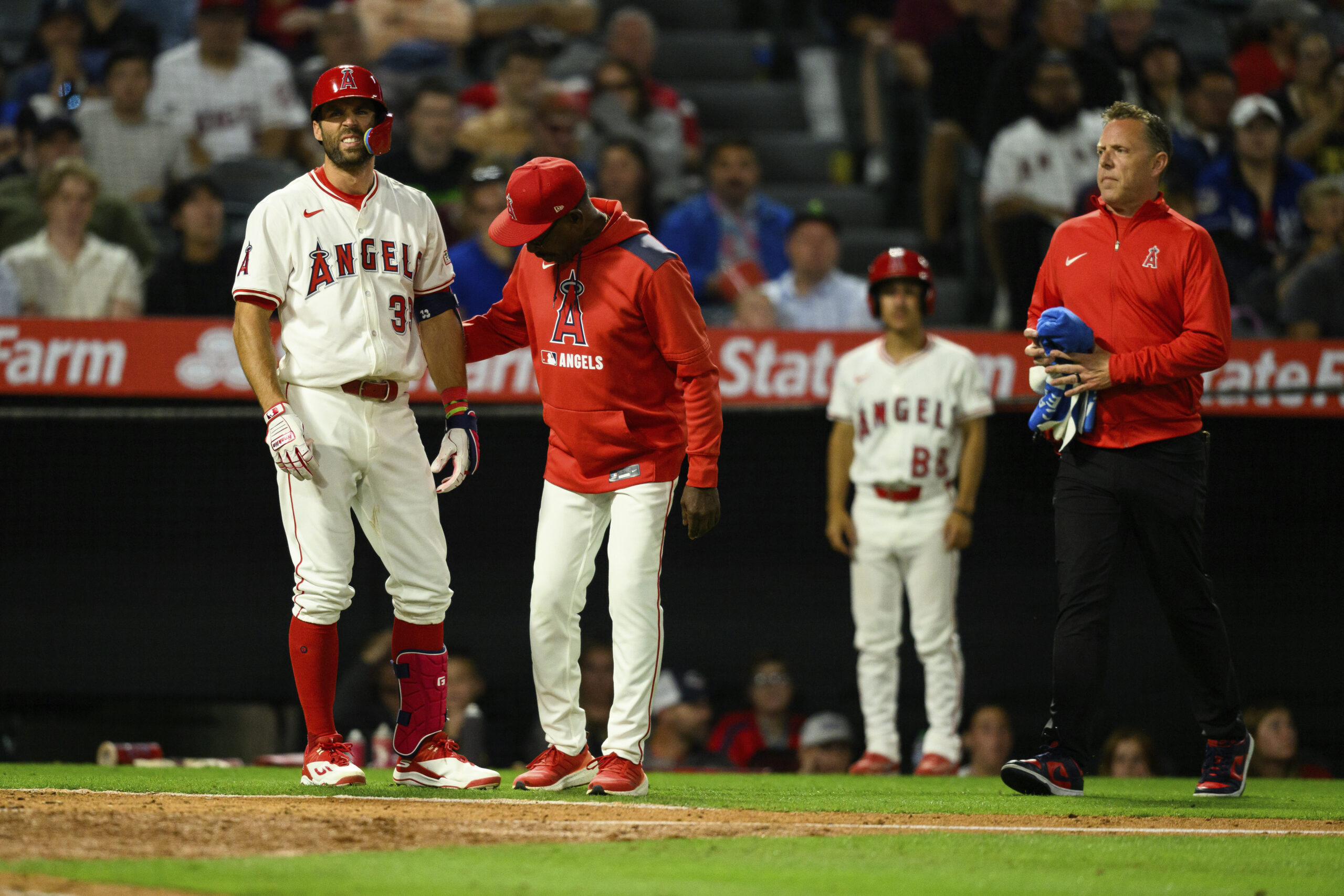 The Angels’ Chris Taylor reacts after being hit by a...