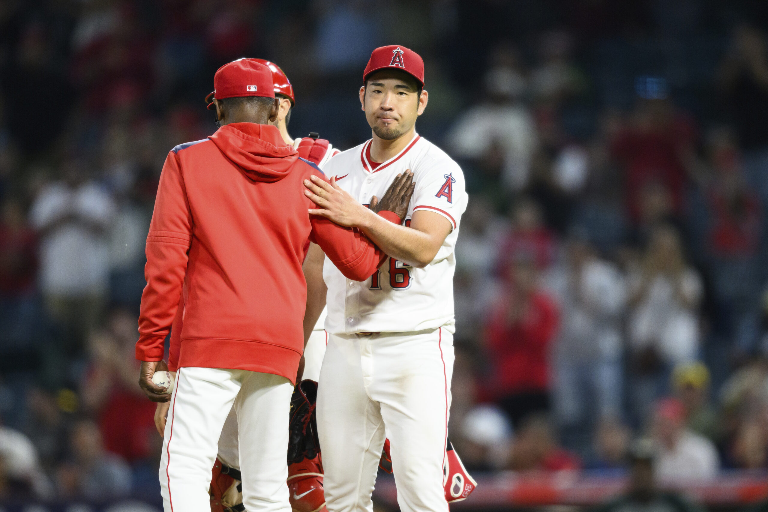 Angels starting pitcher Yusei Kikuchi looks on as Manager Ron...
