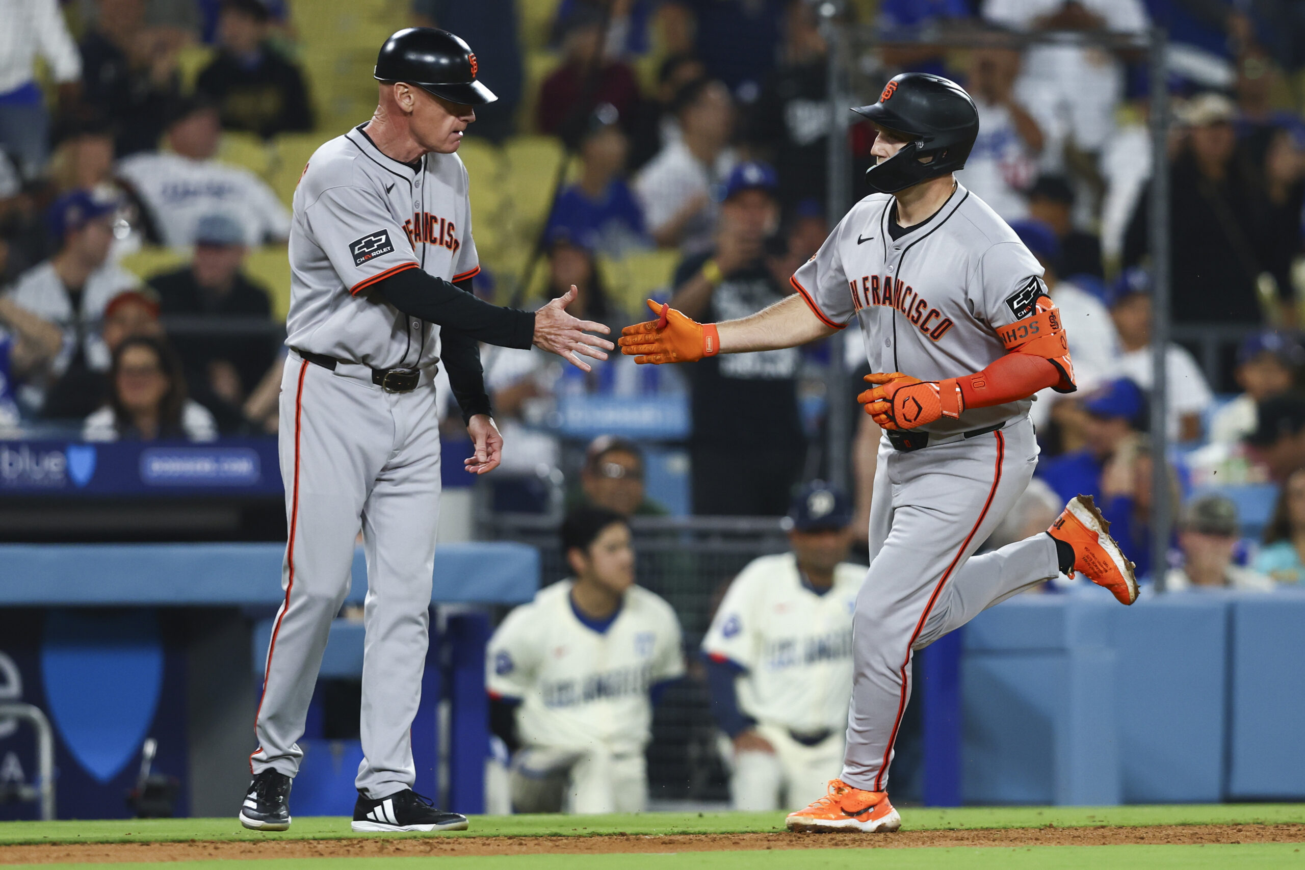 San Francisco Giants’ Casey Schmitt celebrates with third base coach...
