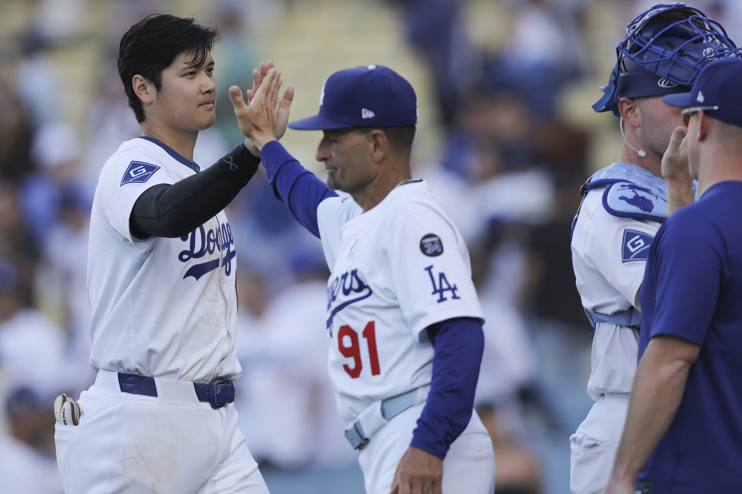 Dodgers’ Shohei Ohtani, left, celebrates with third base coach Dino...