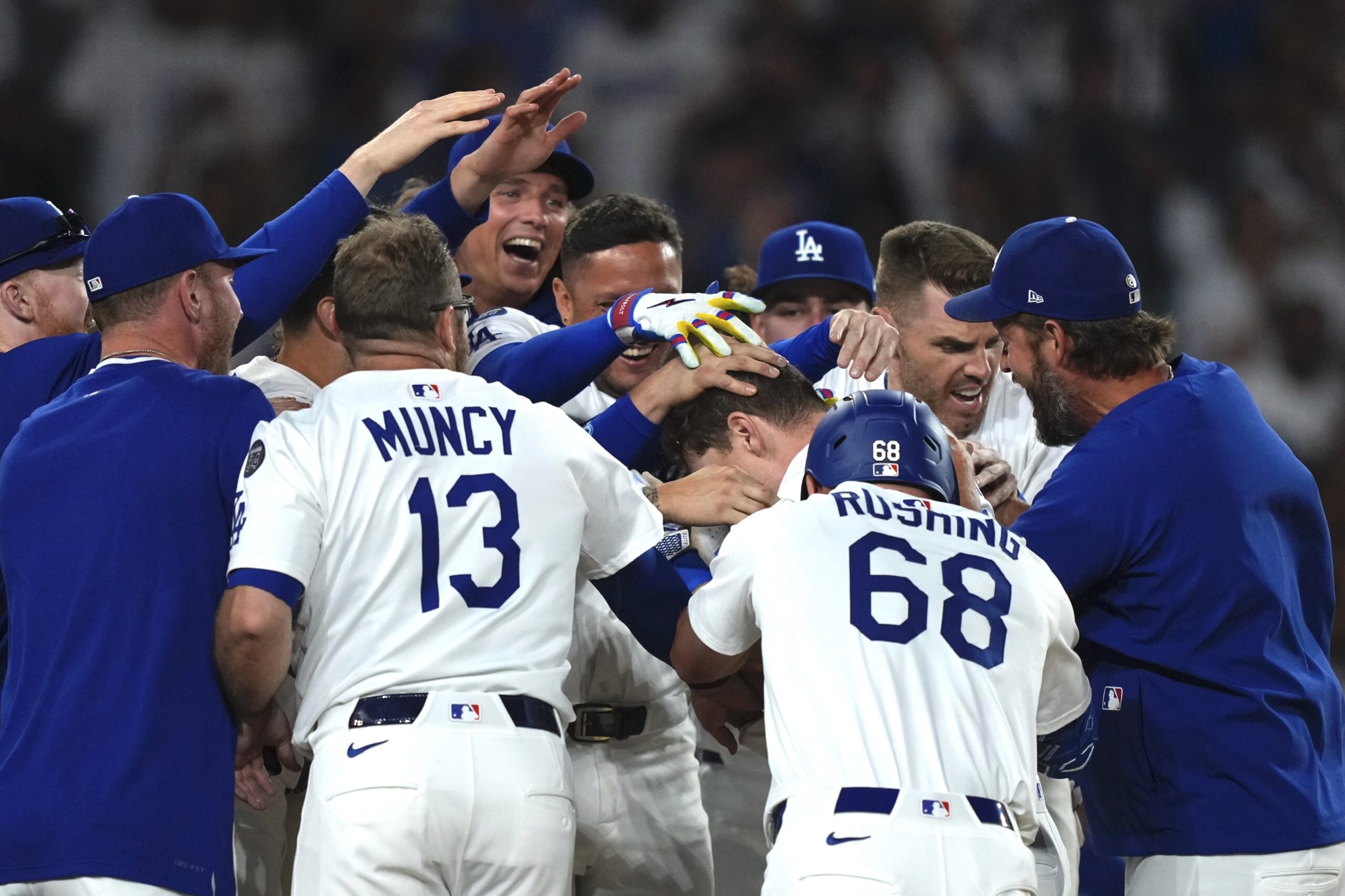 The Dodgers’ Will Smith, center, is mobbed by teammates after...