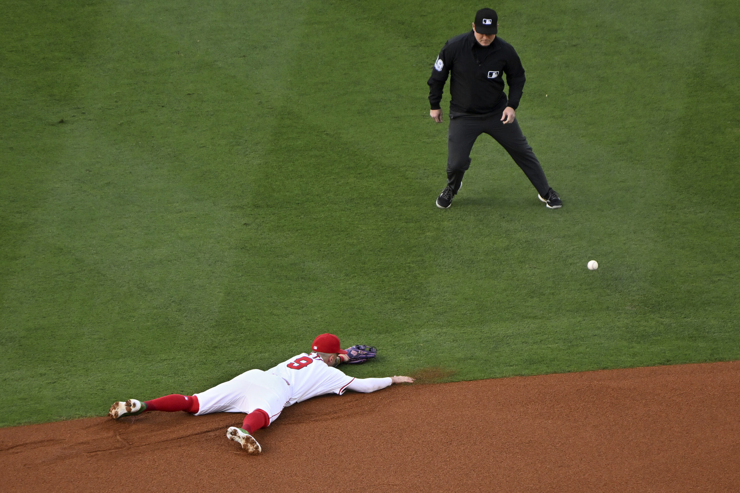 Angels shortstop Zach Neto (9) dives for a ball on...