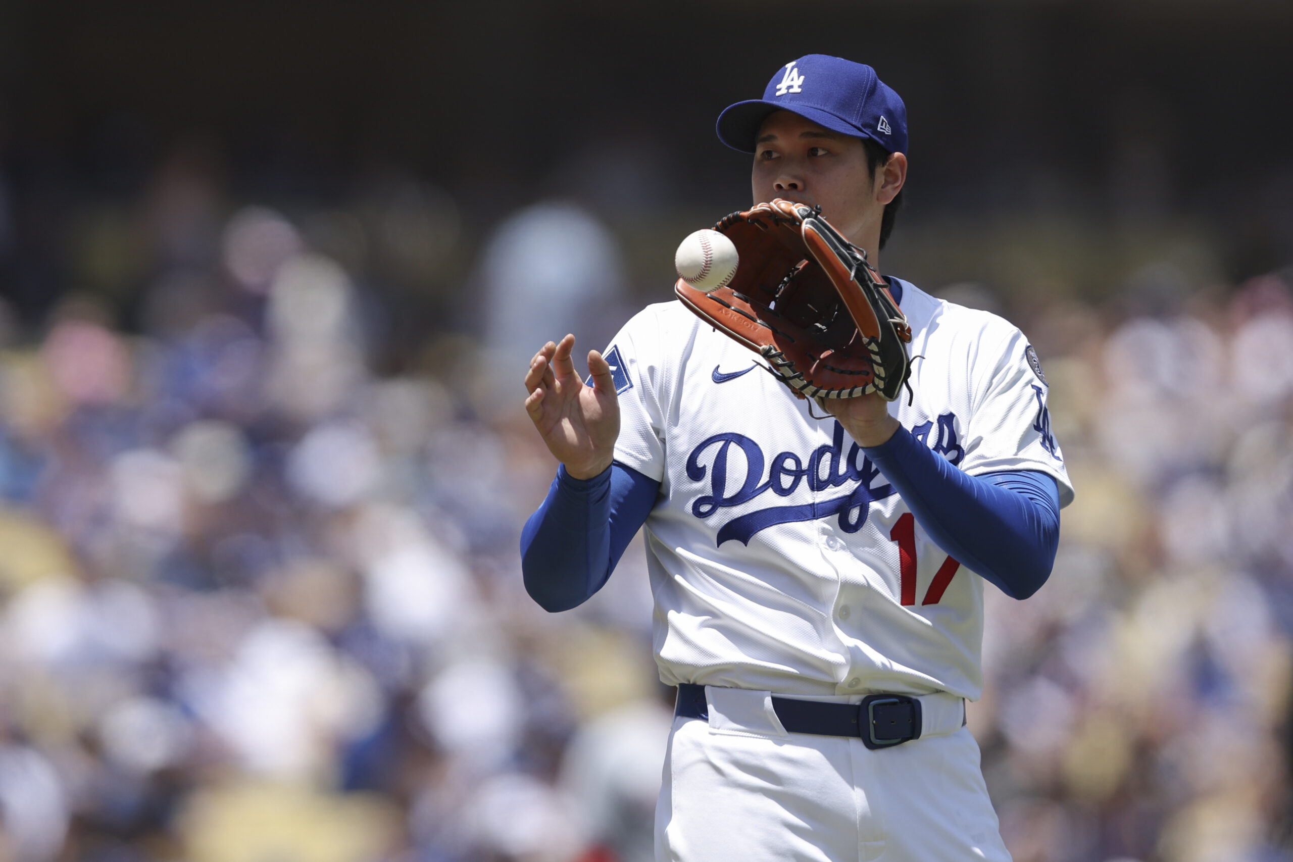 Dodgers starting pitcher Shohei Ohtani catches the ball during the...
