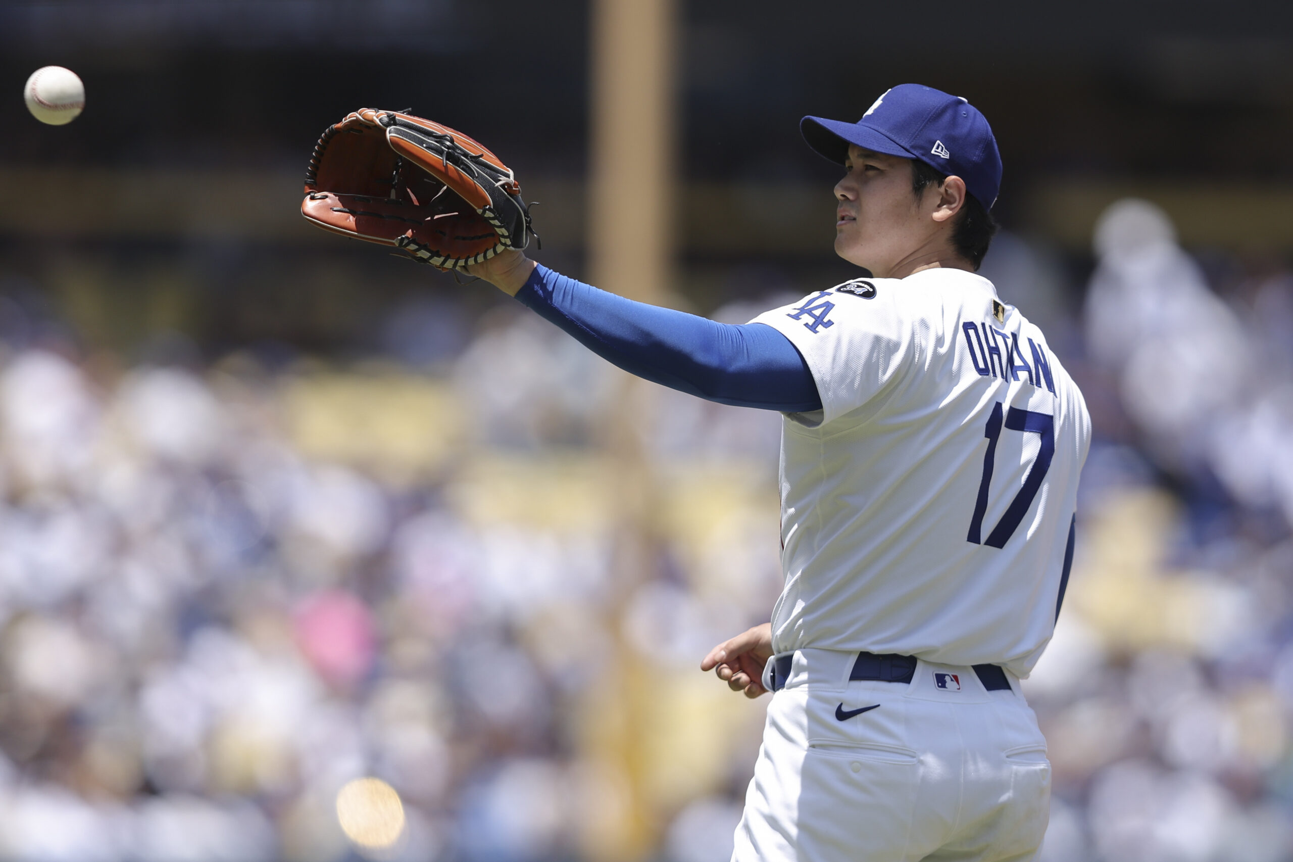 Dodgers starting pitcher Shohei Ohtani catches the ball during the...