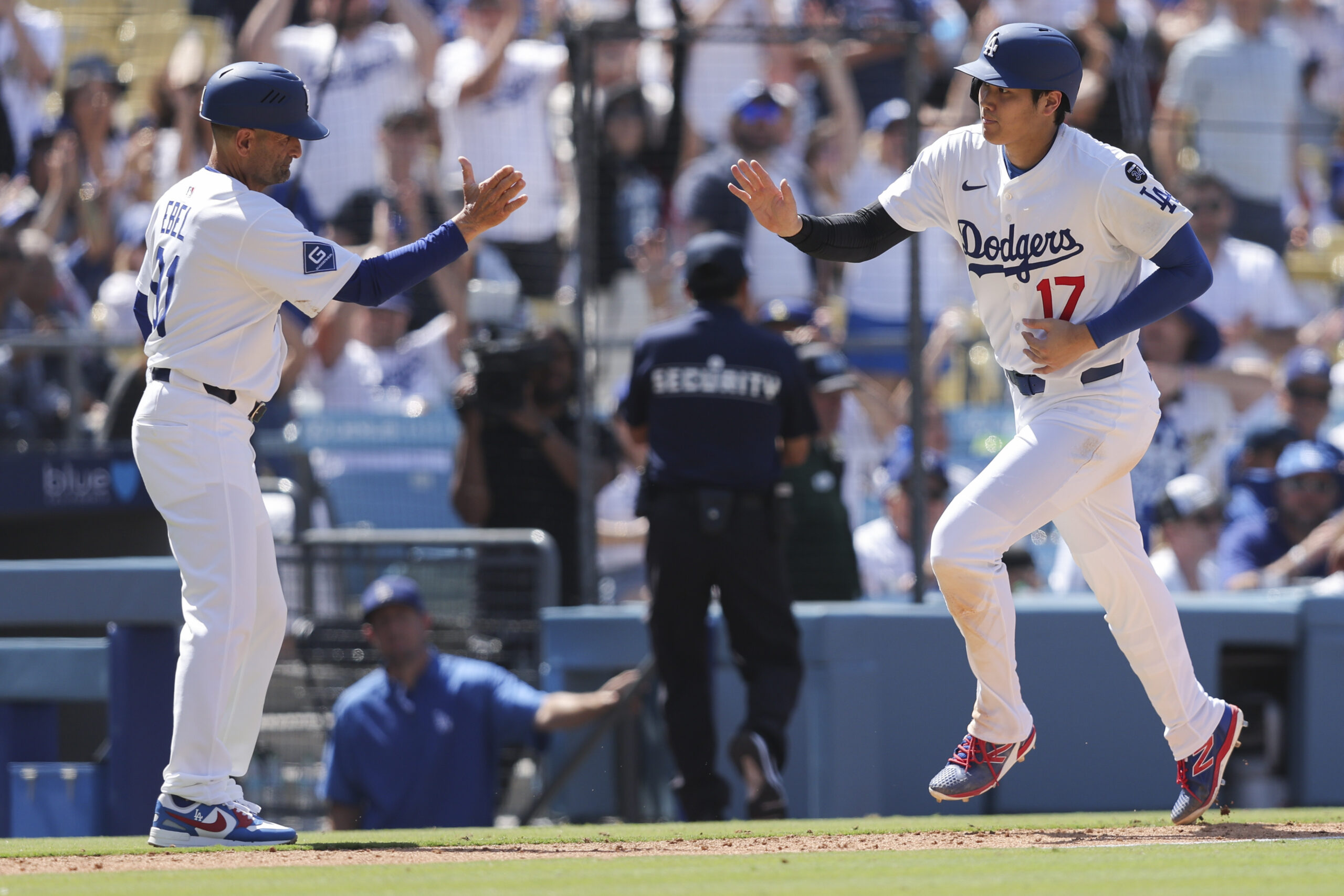 Dodgers’ Shohei Ohtani celebrates with third base coach Dino Ebel...