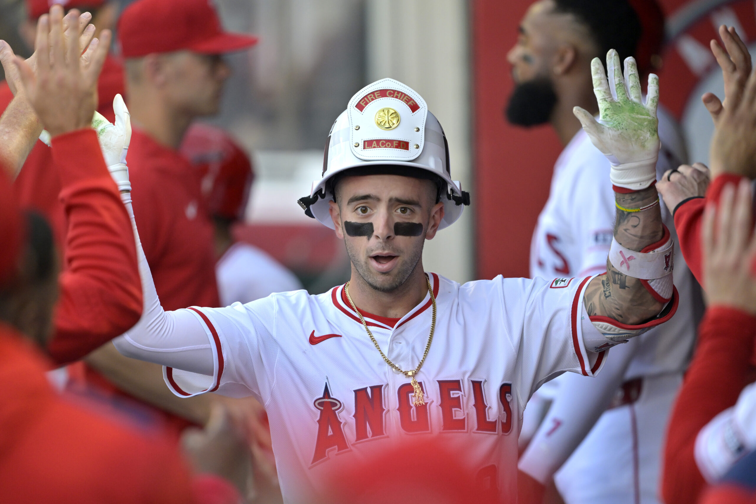 The Angels’ Zach Neto is congratulated in the dugout after...