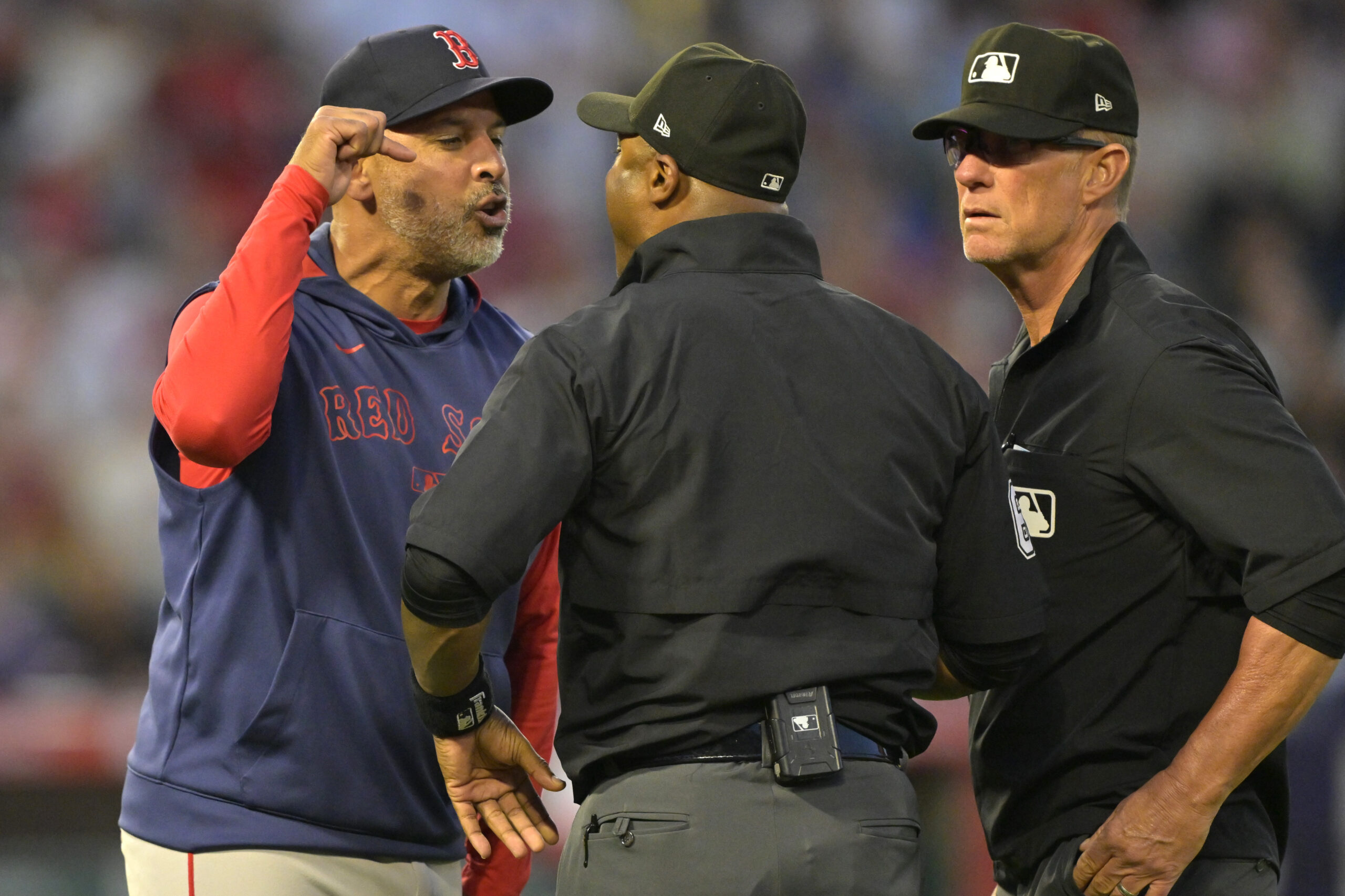 Boston Red Sox manager Alex Cora, left, argues with umpire...