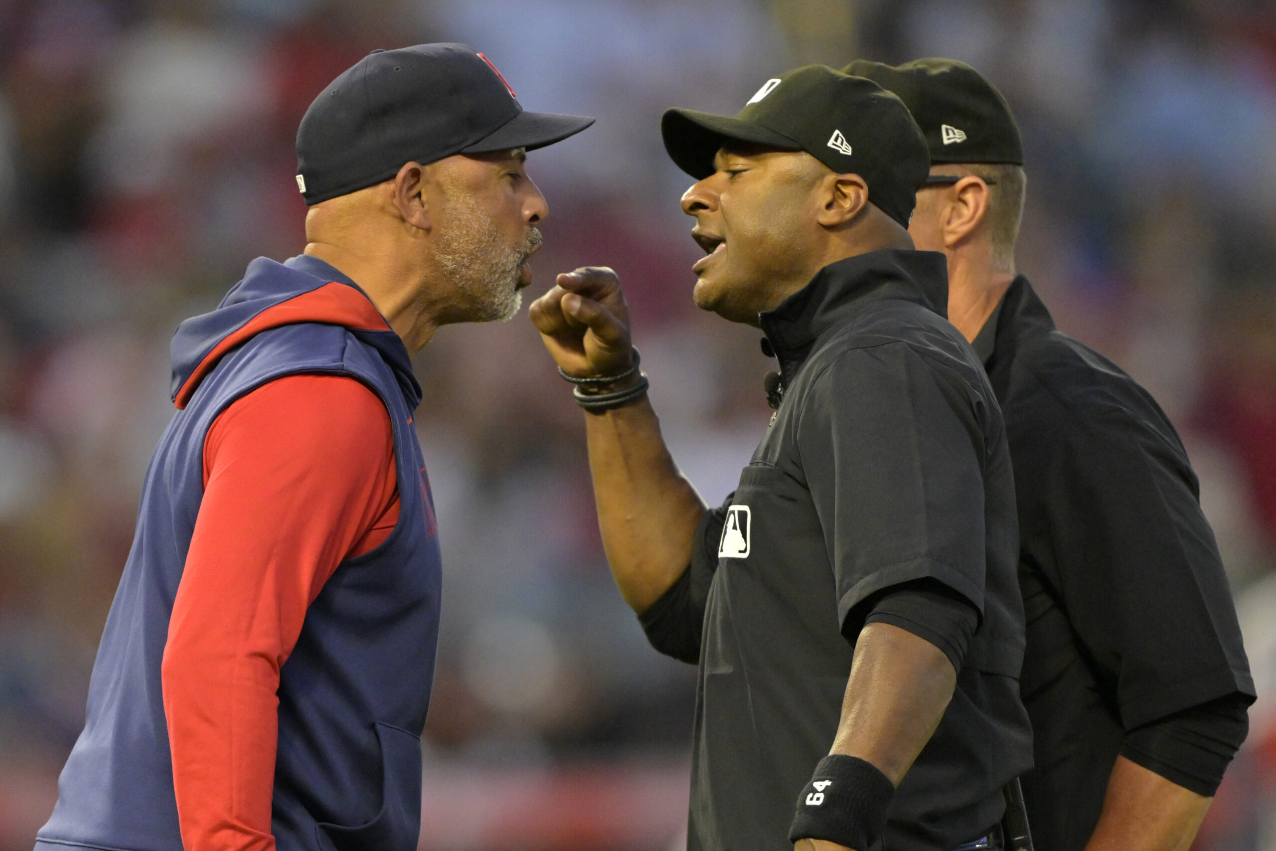 Boston Red Sox manager Alex Cora, left, argues with umpire...
