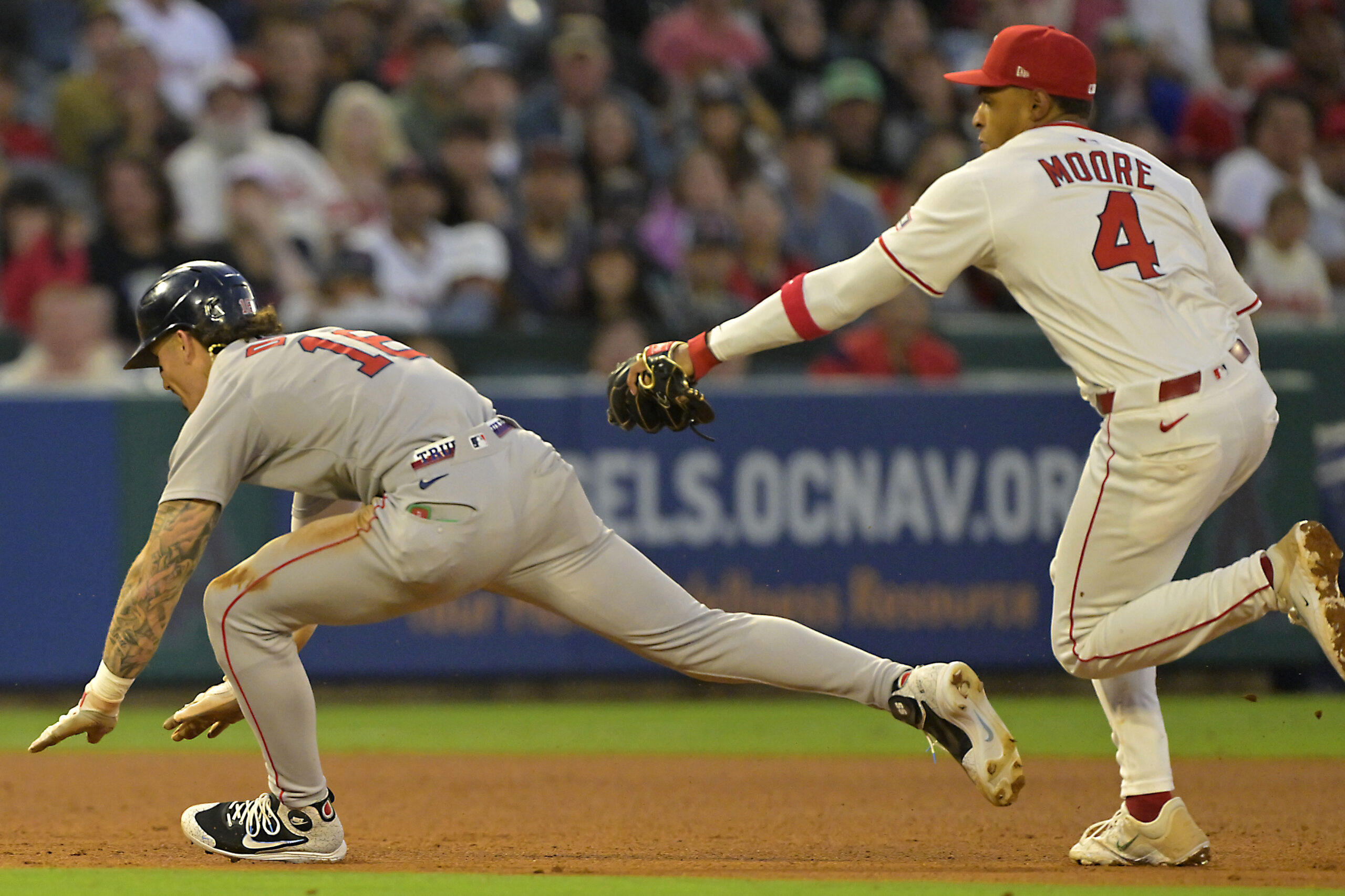 Angels second baseman Christian Moore, right, tags out the Boston...