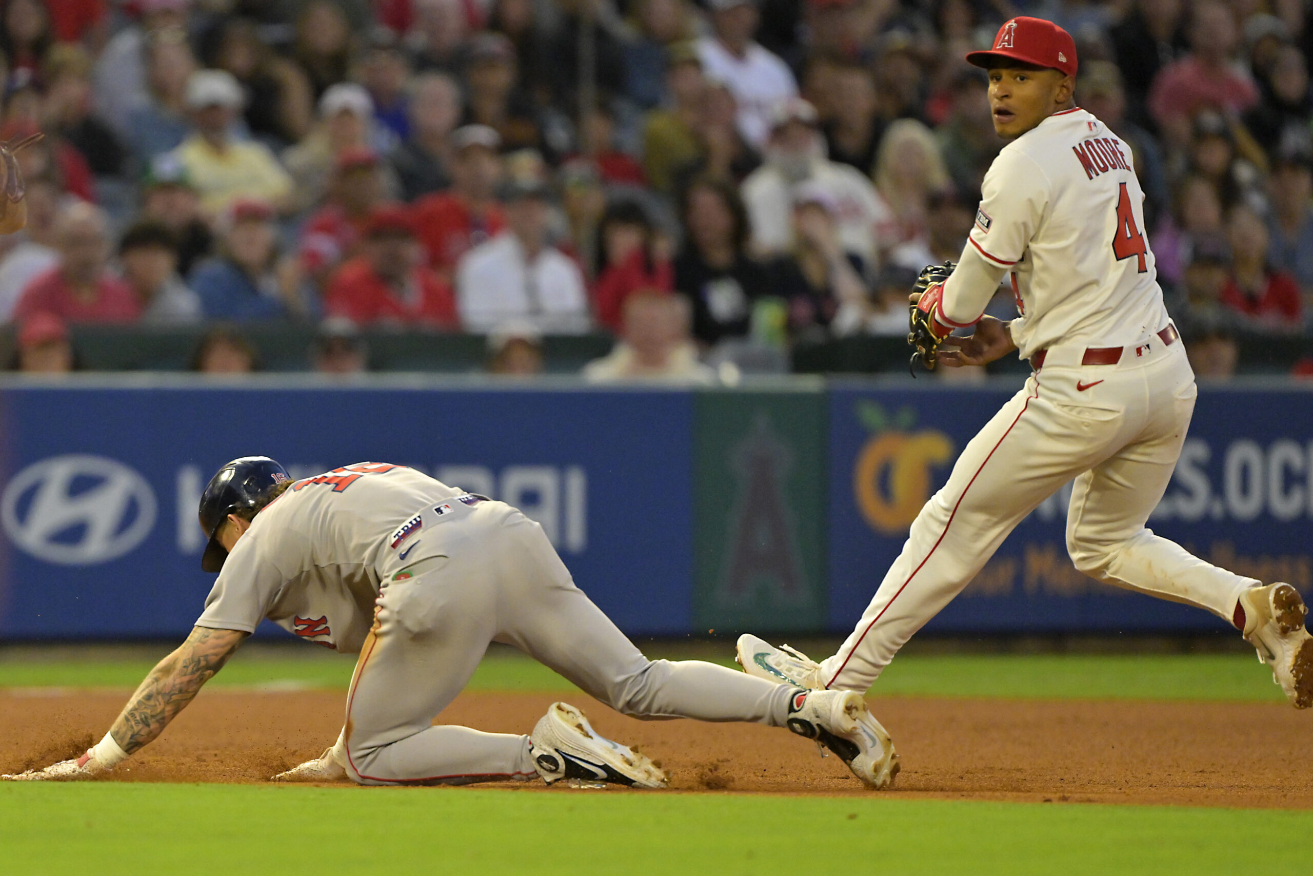 Angels second baseman Christian Moore, right, tags out the Boston...