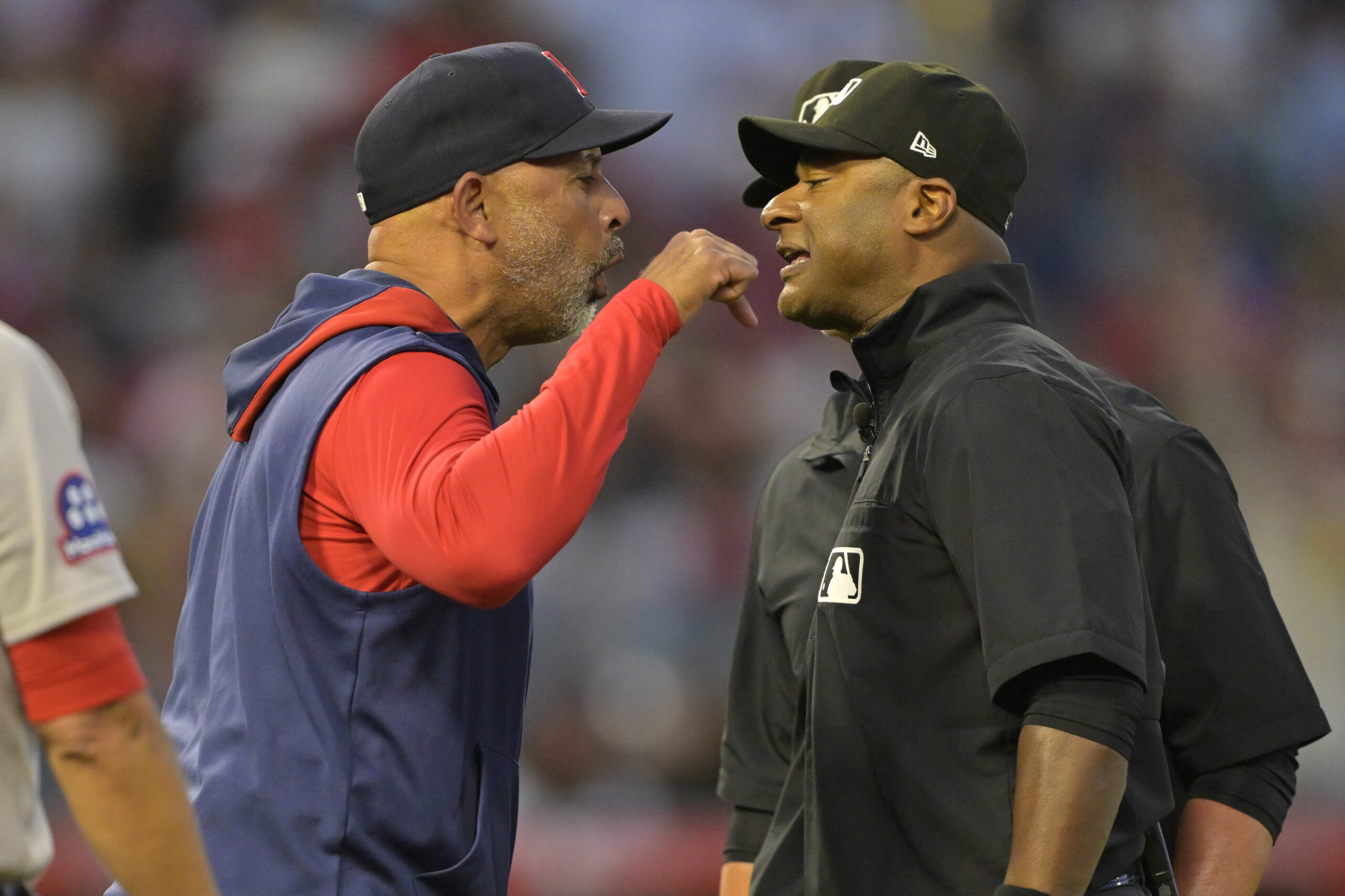 Boston Red Sox manager Alex Cora, left, argues with umpire...