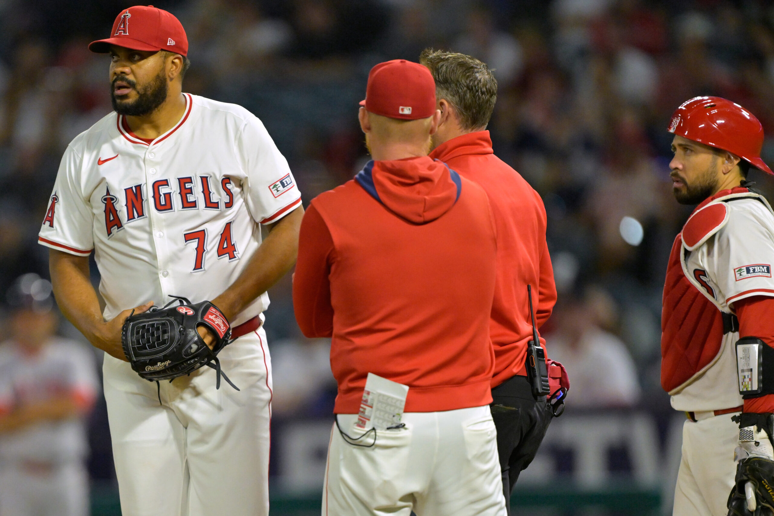 Angels relief pitcher Kenley Jansen, left, is checked on by...