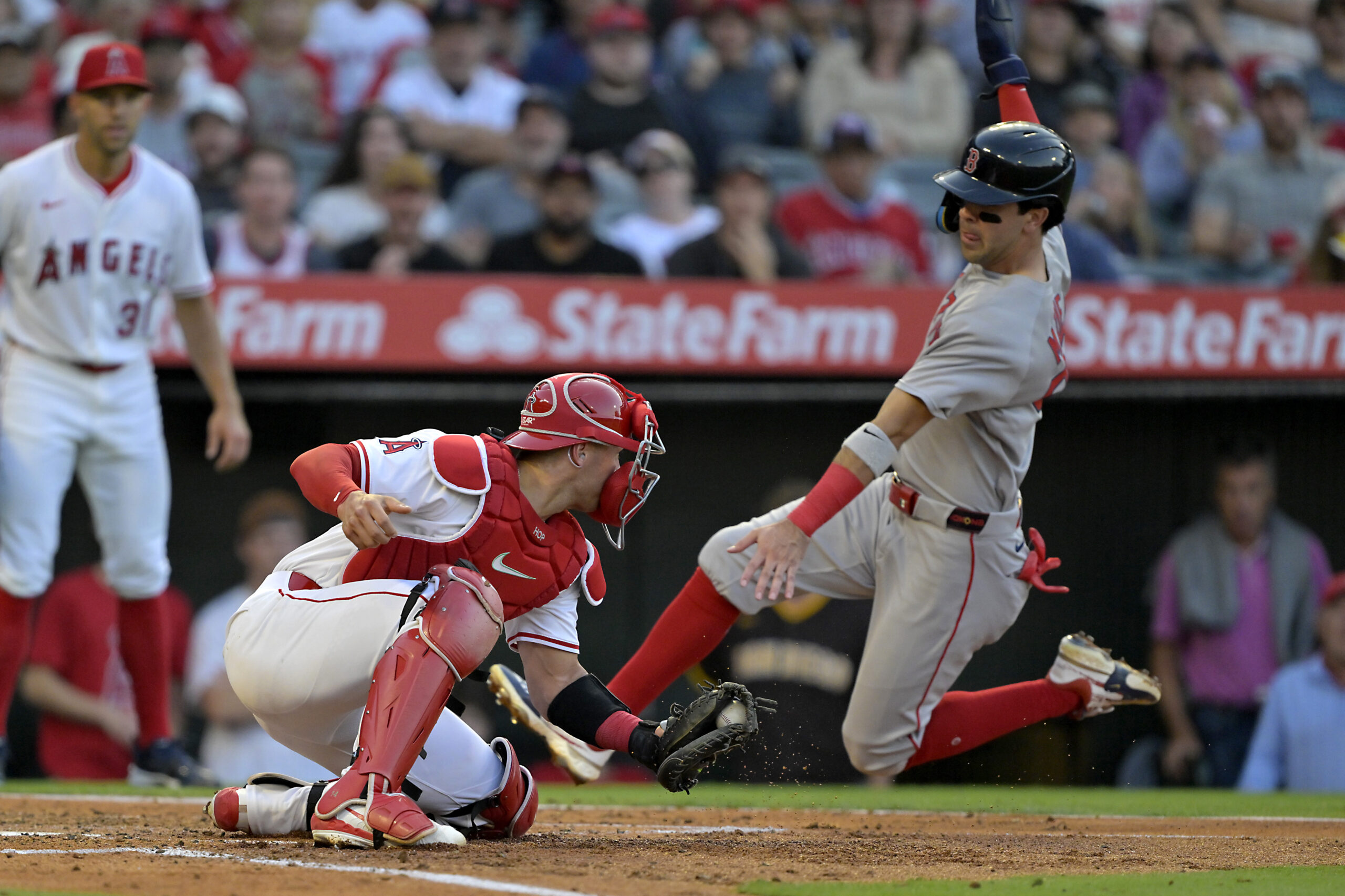 The Boston Red Sox’s Marcelo Mayer, right, scores past Angels...