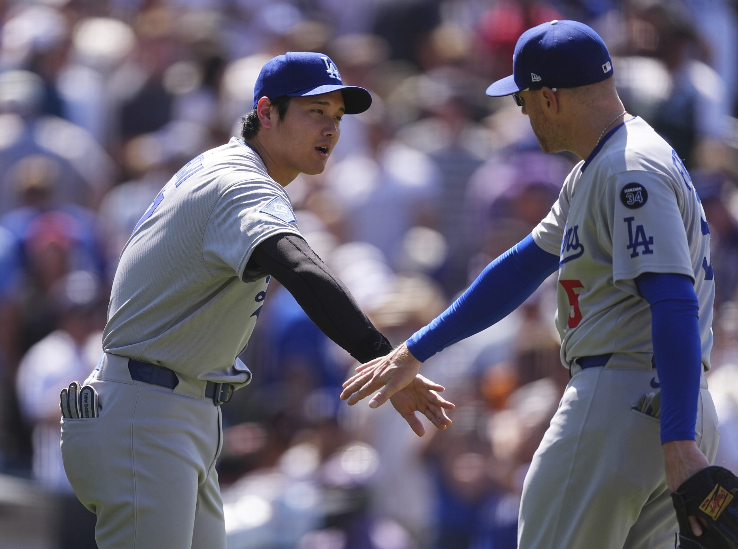 Dodgers star Shohei Ohtani, left, congratulates first baseman Freddie Freeman...