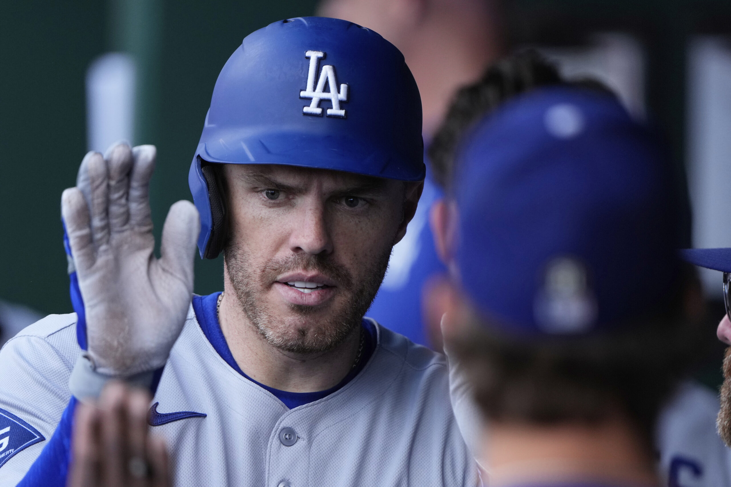 Dodgers’ Freddie Freeman celebrates in the dugout after hitting a...