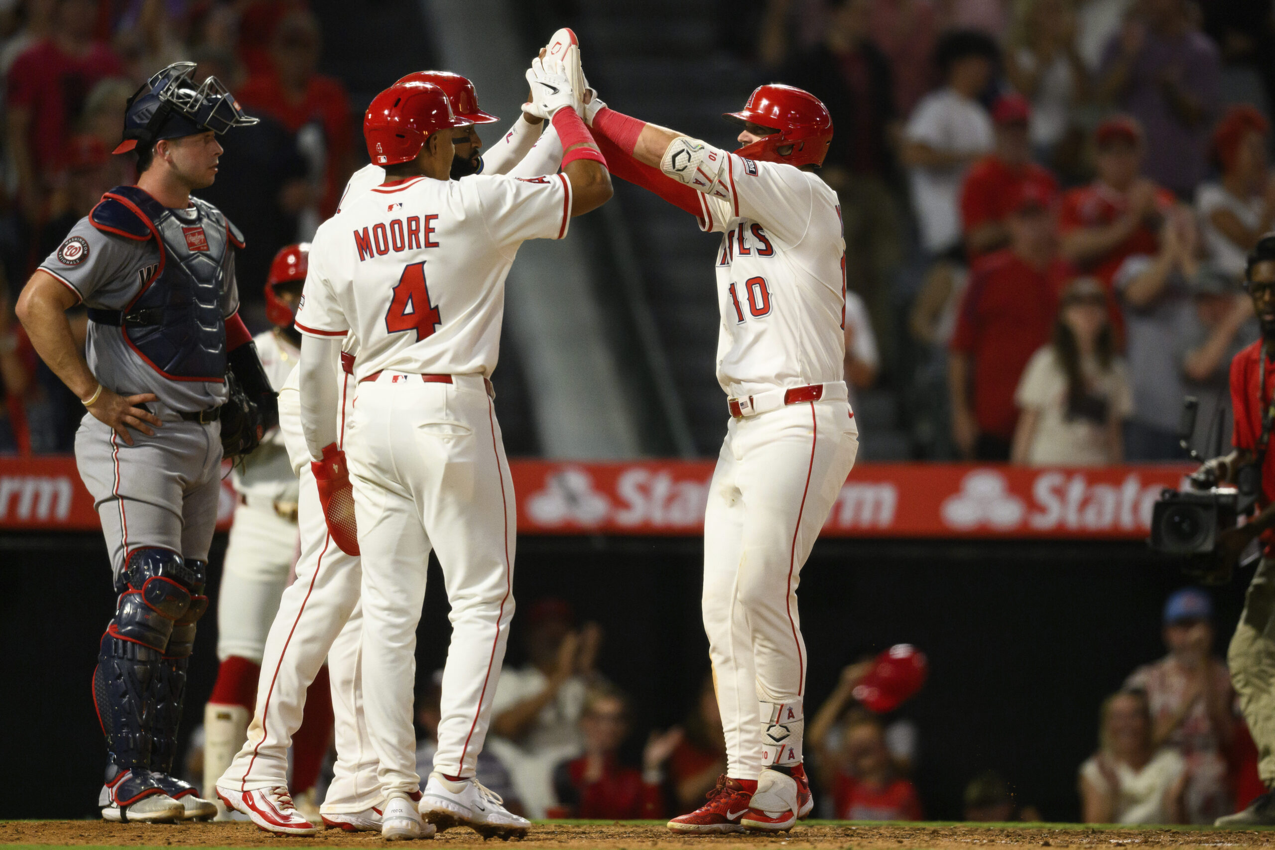 Angels’ Kevin Newman, right, celebrates with teammates after hitting a...