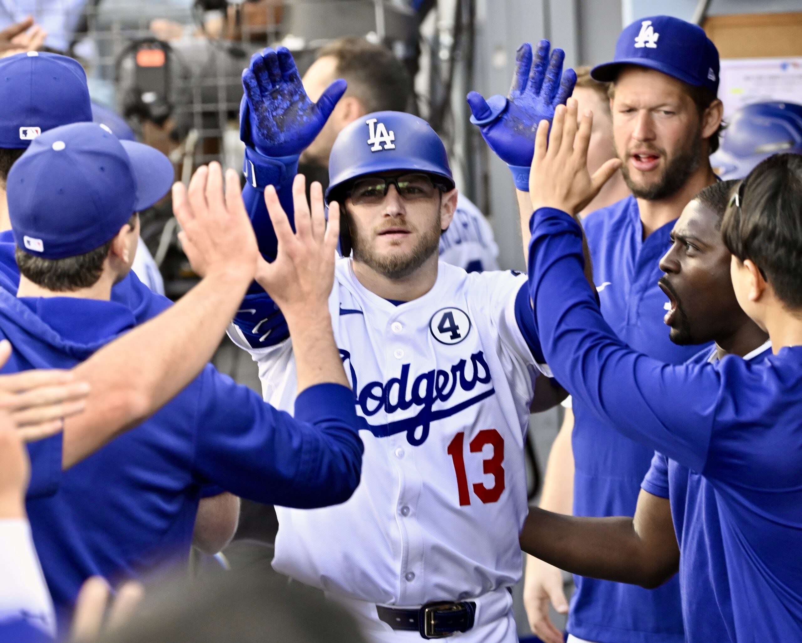 Max Muncy #13 of the Dodgers high fives teammates after...
