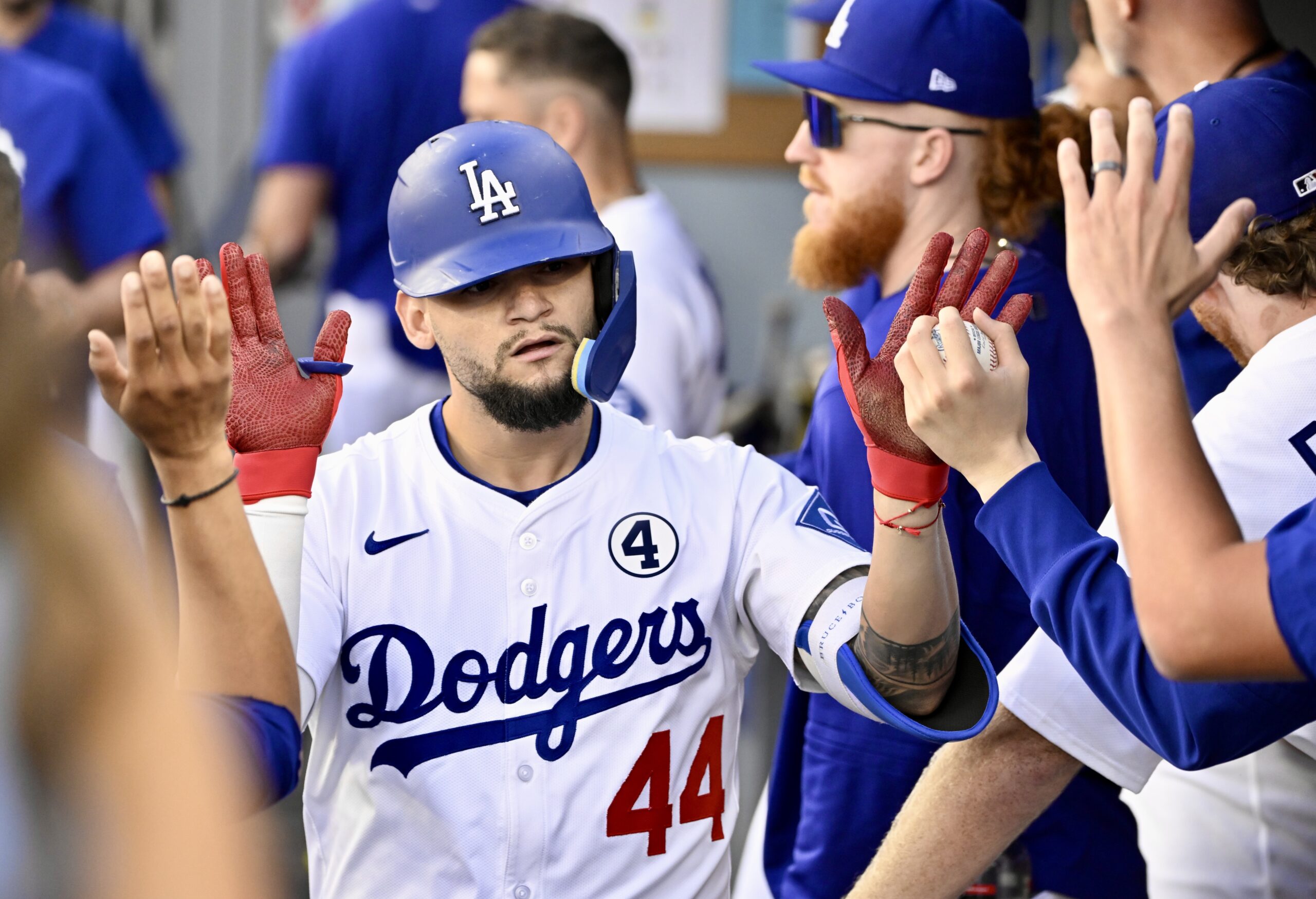 Andy Pages #44 of the Dodgers high fives teammates after...