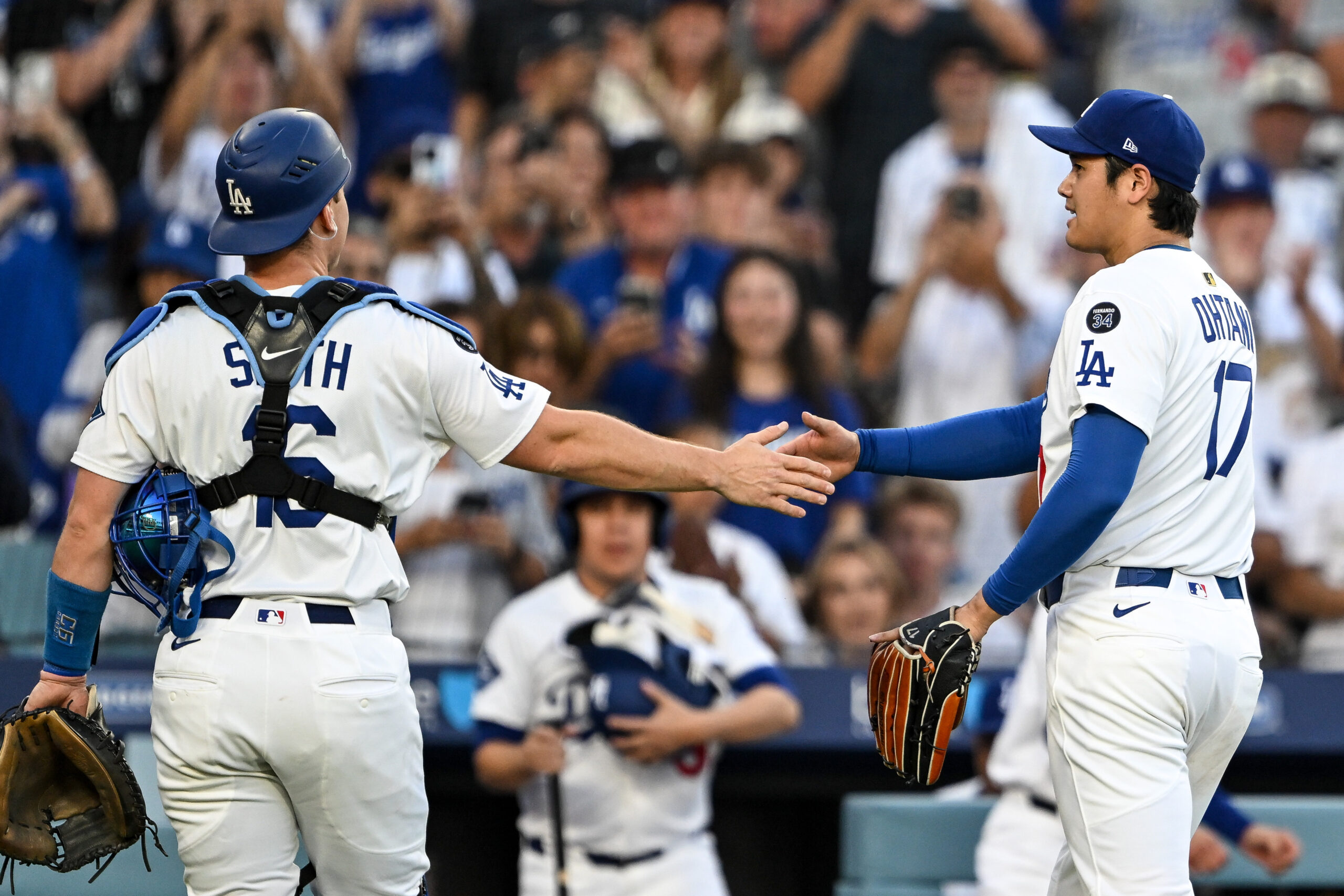 Dodgers catcher Will Smith, left, shakes hands with pitcher Shohei...