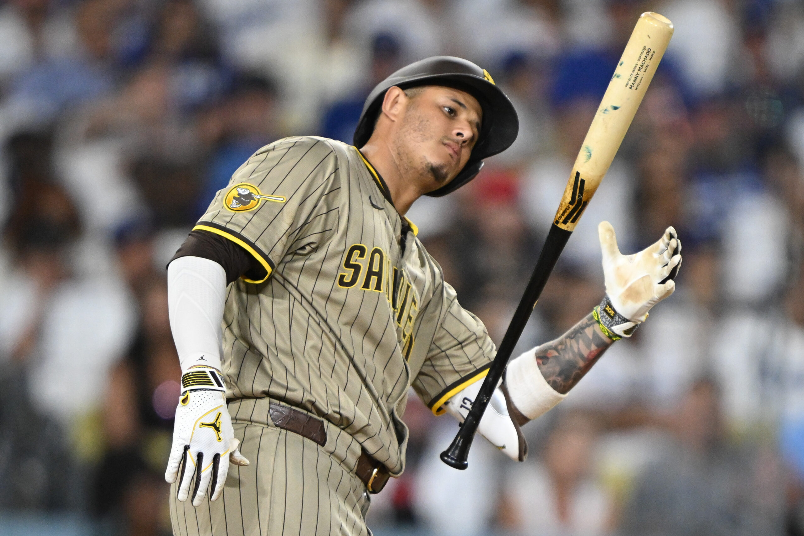 San Diego Padres star Manny Machado tosses his bat in...