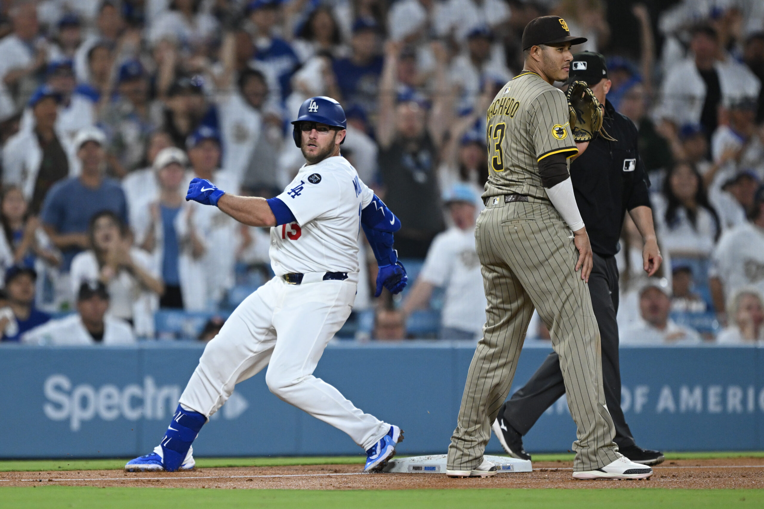The Dodgers’ Max Muncy arrives at third base after hitting...