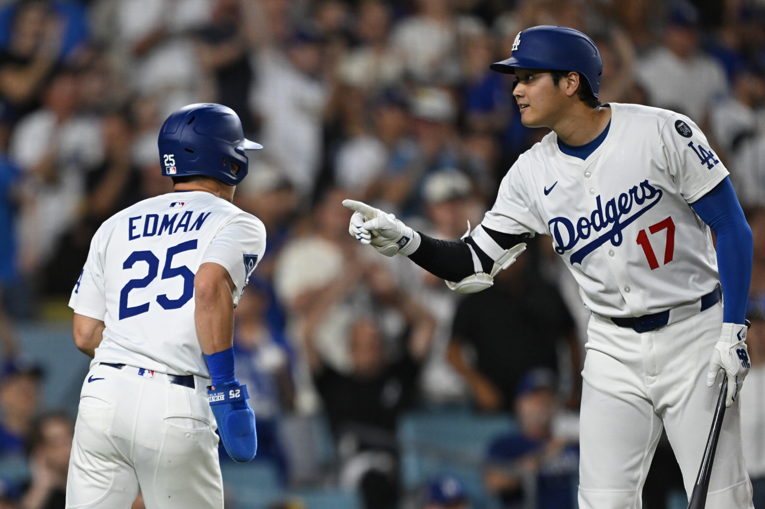 The Dodgers’ Tommy Edman, left, is met by teammate Shohei...