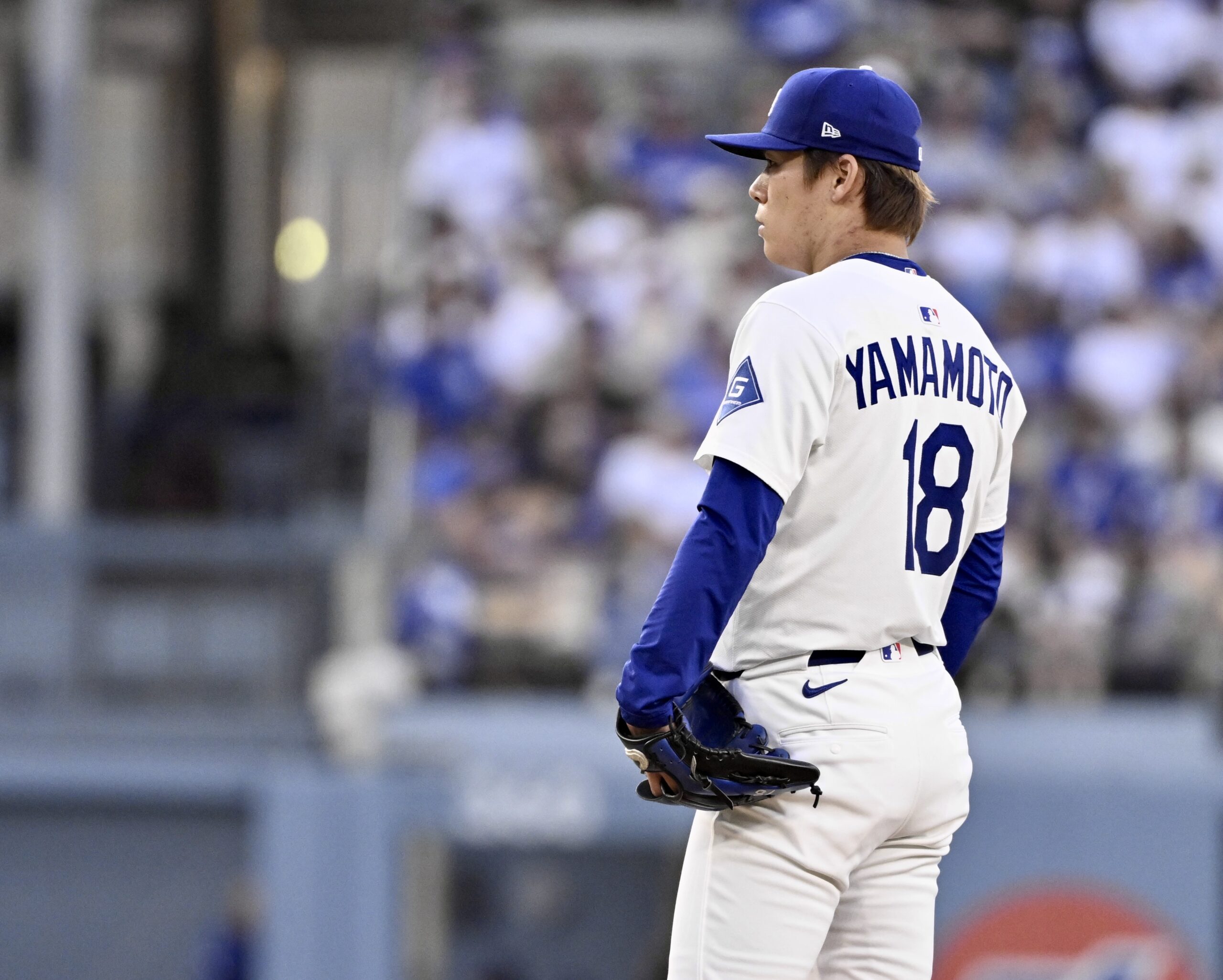 Dodgers starting pitcher Yoshinobu Yamamoto reacts after giving up a...