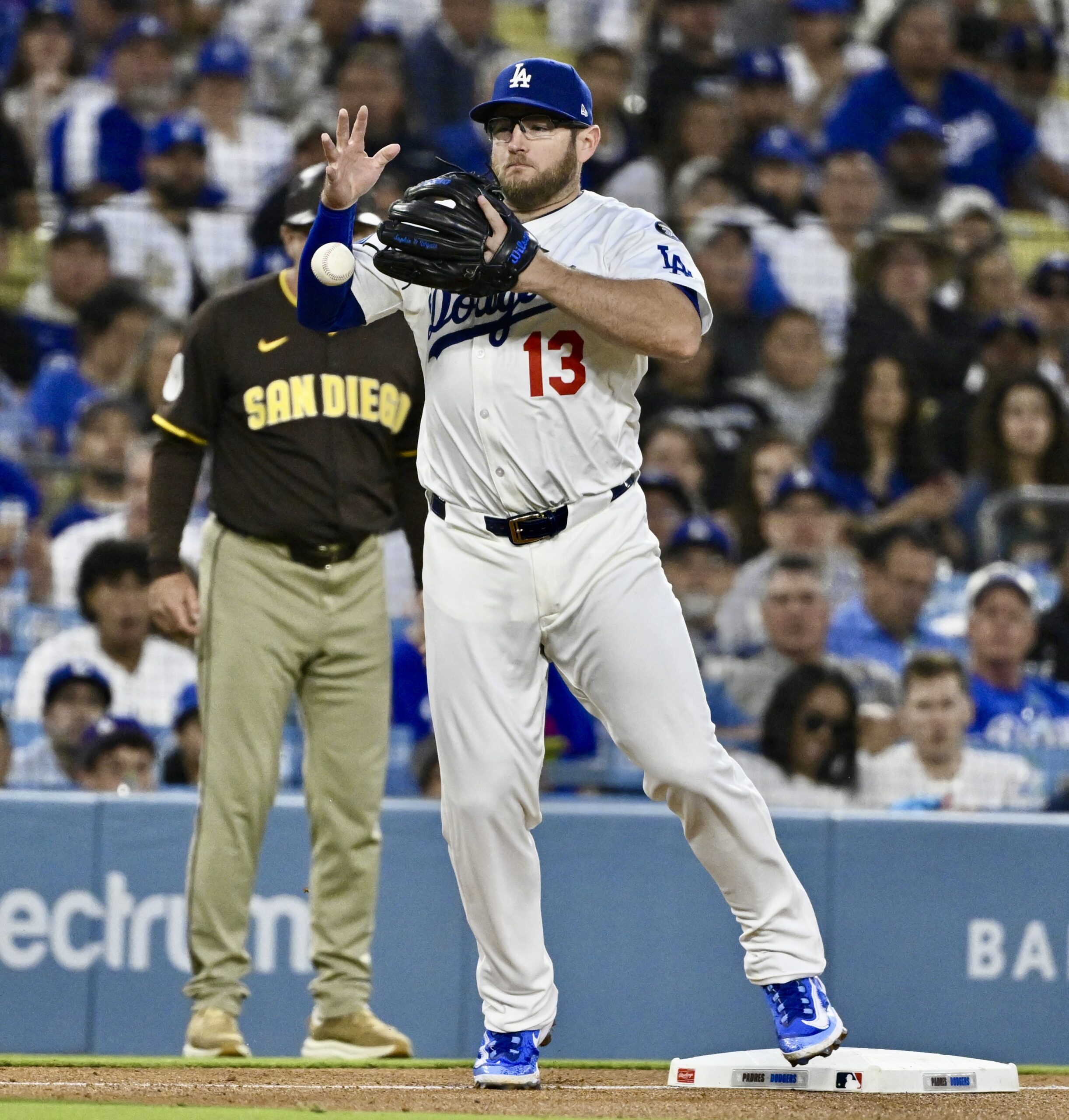 Dodgers third baseman Max Muncy bobbles a ball hit by...