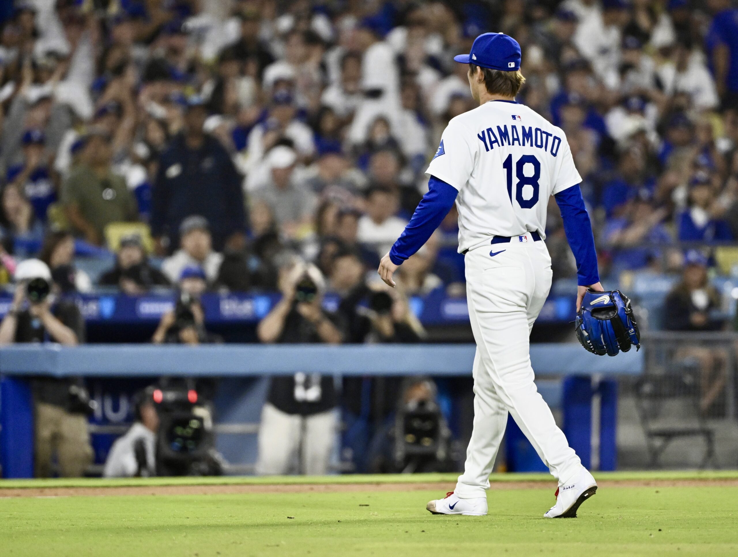 Dodgers starting pitcher Yoshinobu Yamamoto walks off the mound after...