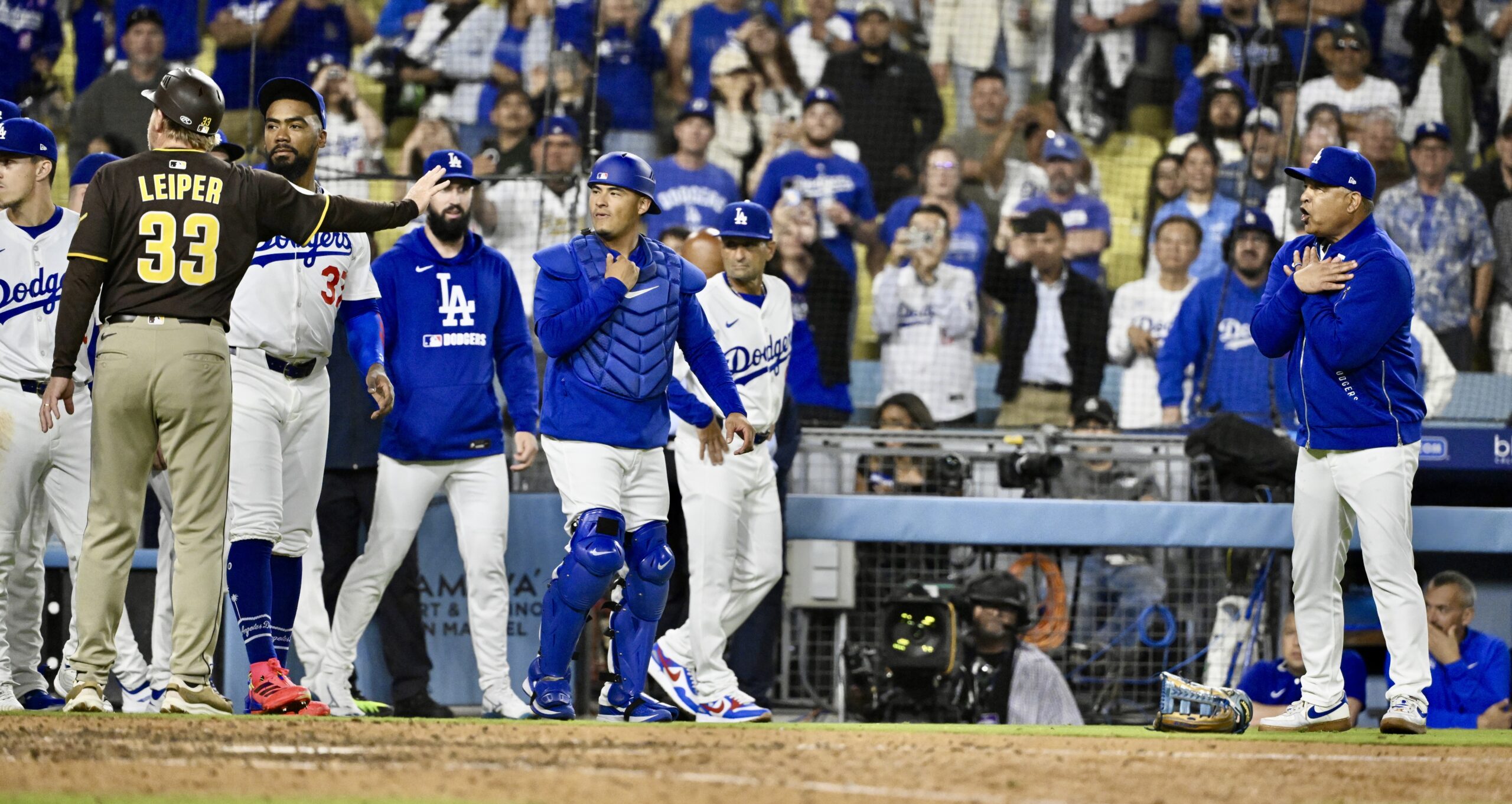 Dodgers manager Dave Roberts, far right, reacts after the benches...