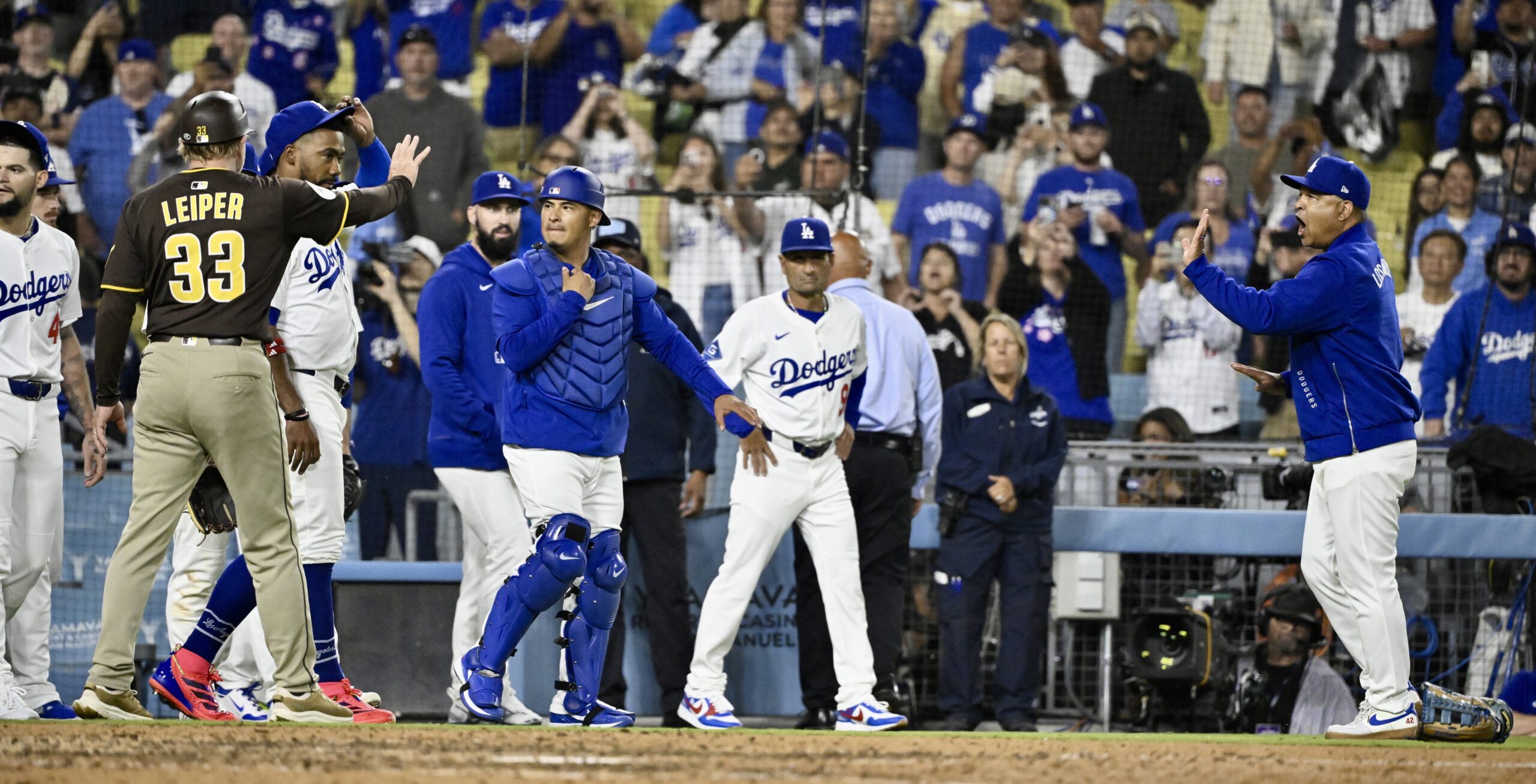 Dodgers manager Dave Roberts, far right, reacts after the benches...