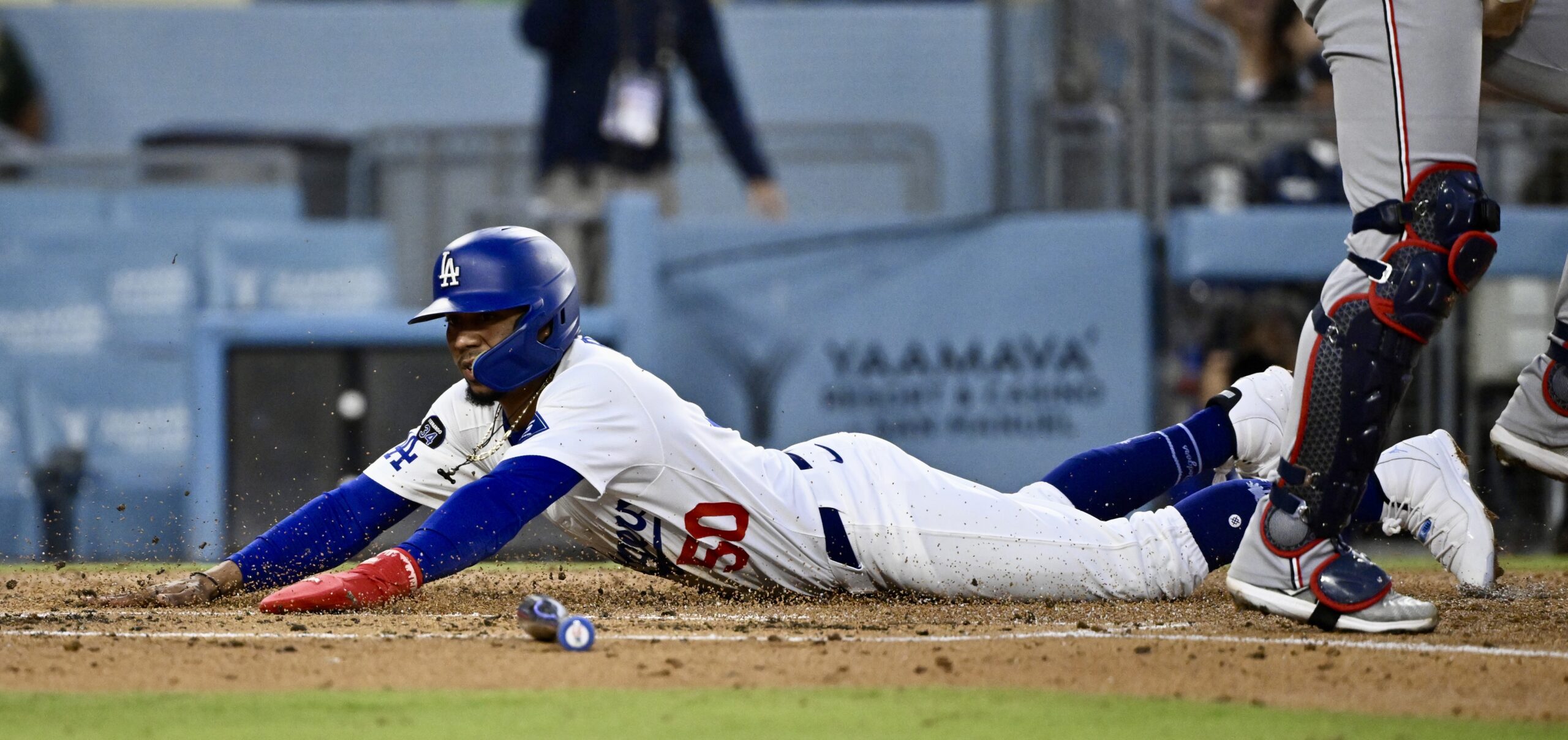 The Dodgers’ Mookie Betts slides home to score on a...