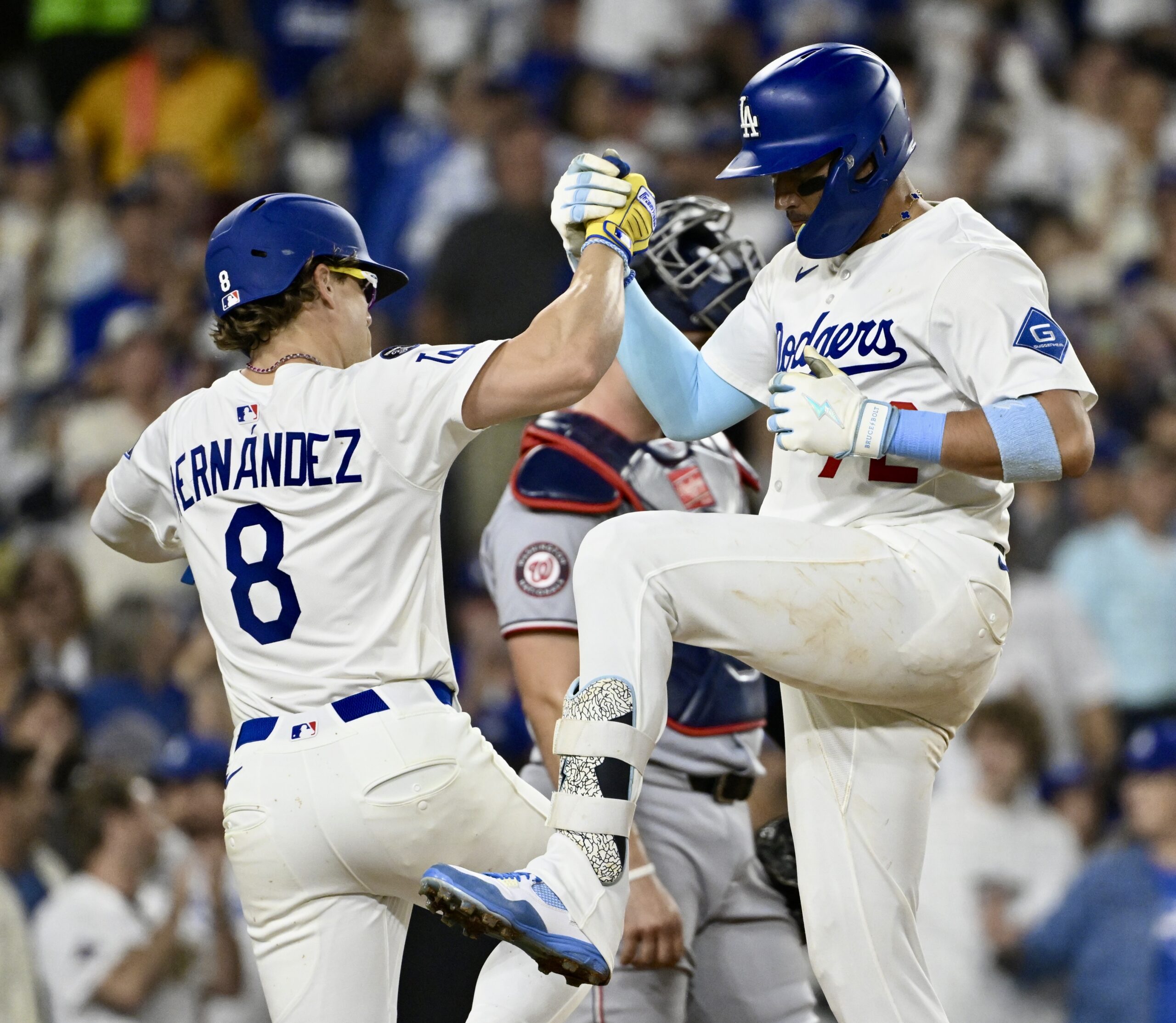 The Dodgers’ Miguel Rojas, right, celebrates with teammate Kike Hernandez...