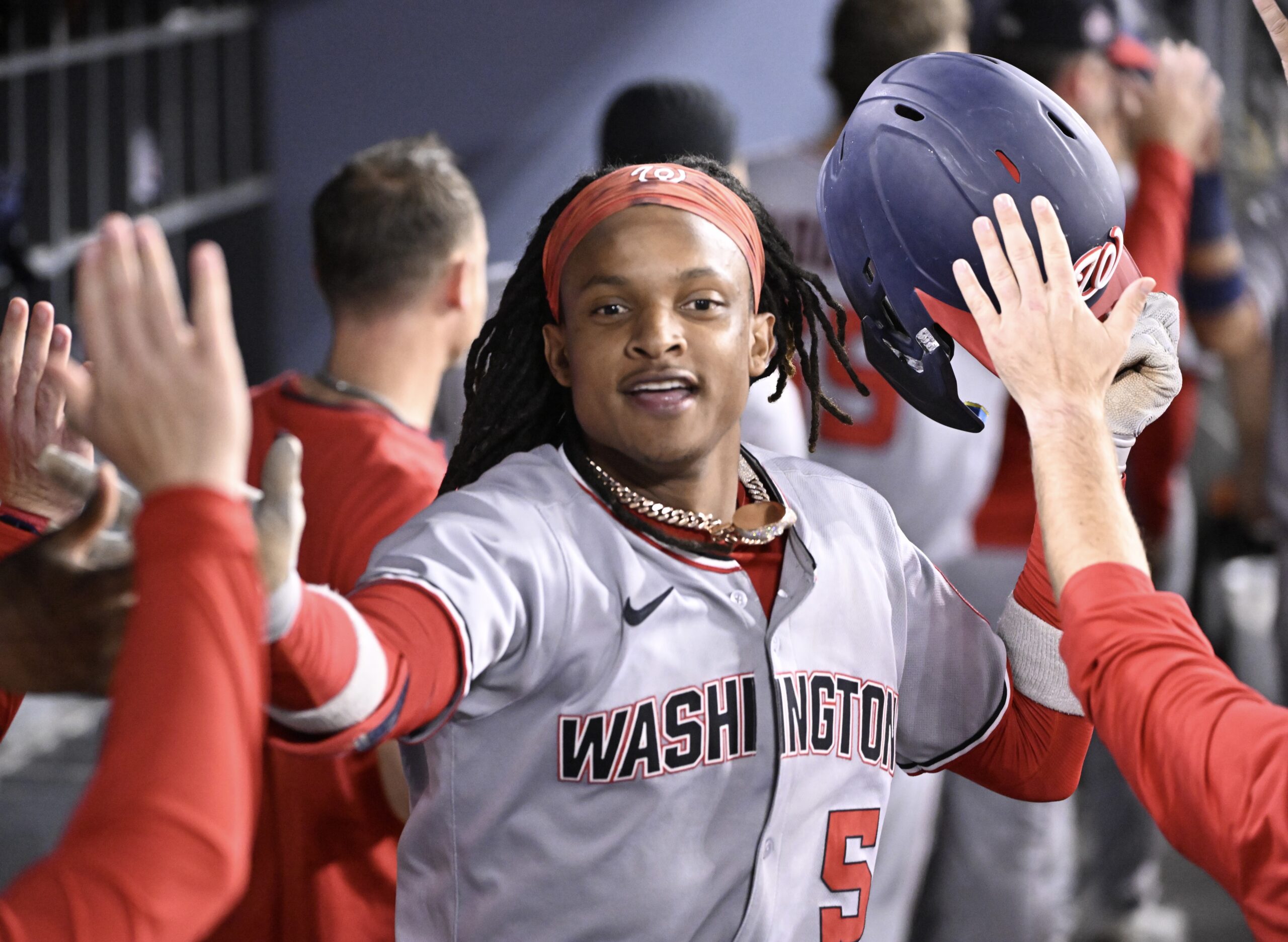 CJ Abrams #5 of the Washington Nationals high fives teammates...