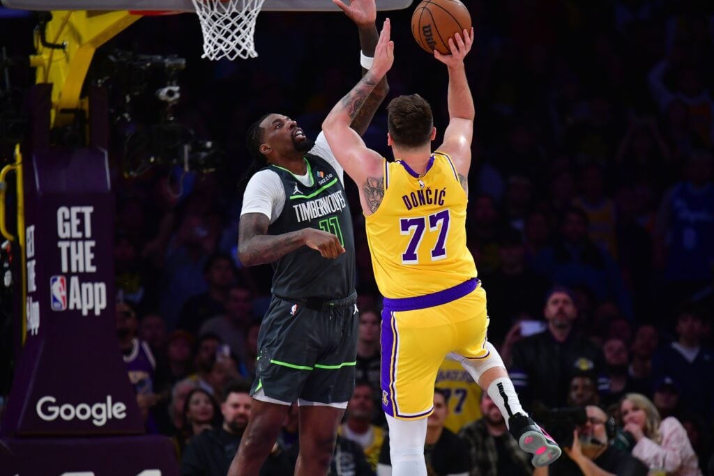 Apr 30, 2025; Los Angeles, California, USA; Los Angeles Lakers guard Luka Doncic (77) shoots against Minnesota Timberwolves center Naz Reid (11) during the second half in game five of first round for the 2025 NBA Playoffs at Crypto.com Arena. Mandatory Credit: Gary A. Vasquez-Imagn Images