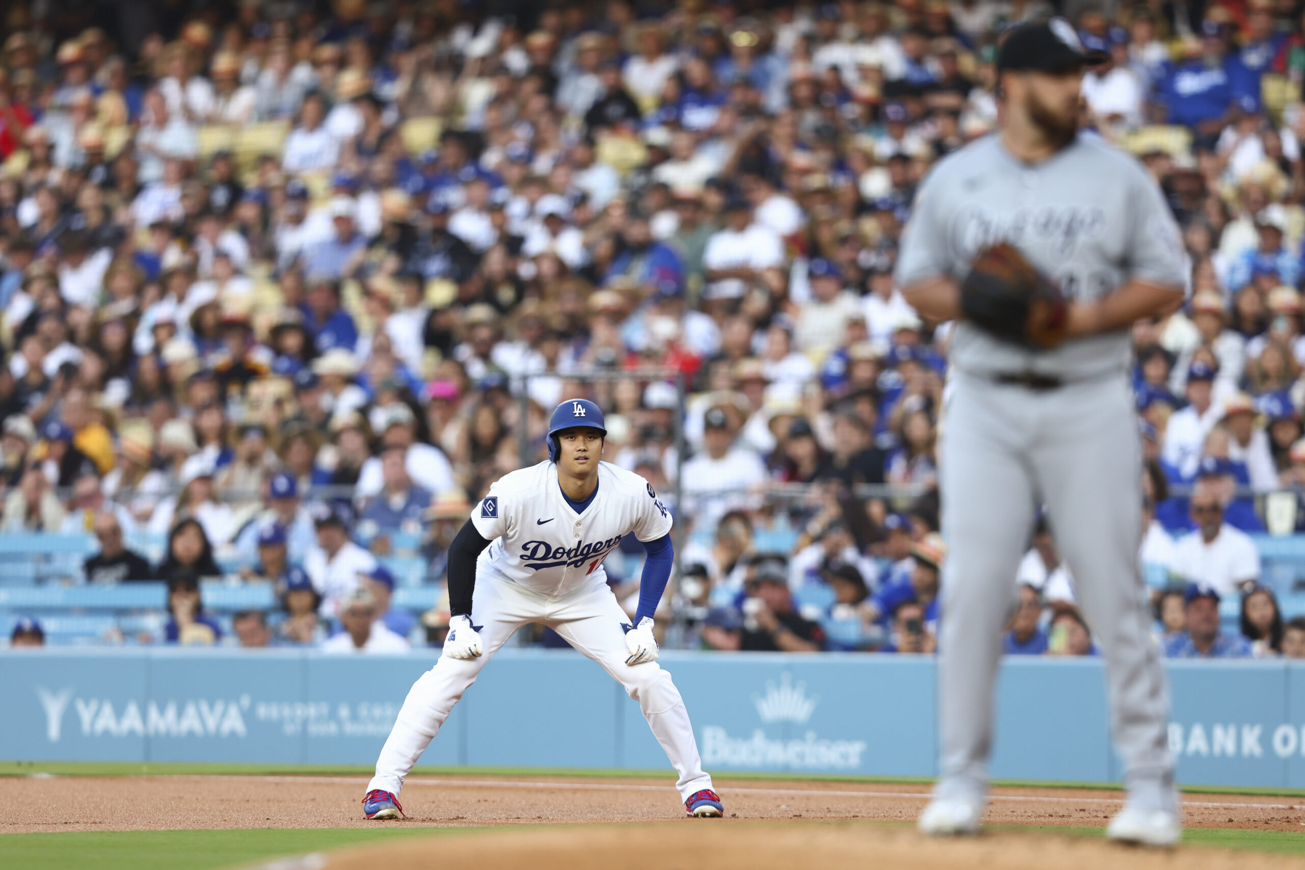 Dodgers star Shohei Ohtani, left, looks on while on base...