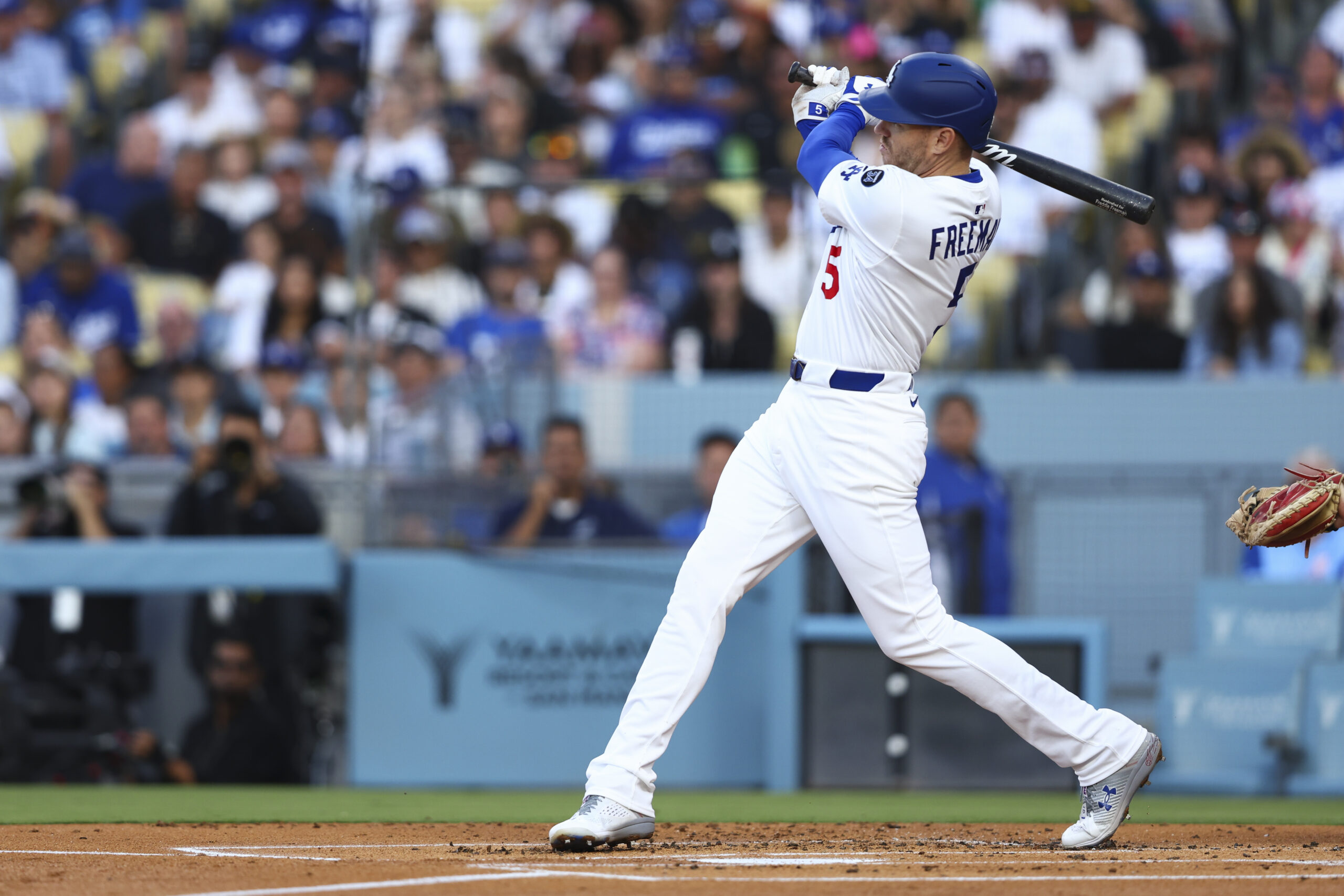 The Dodgers’ Freddie Freeman follows through on an RBI double...