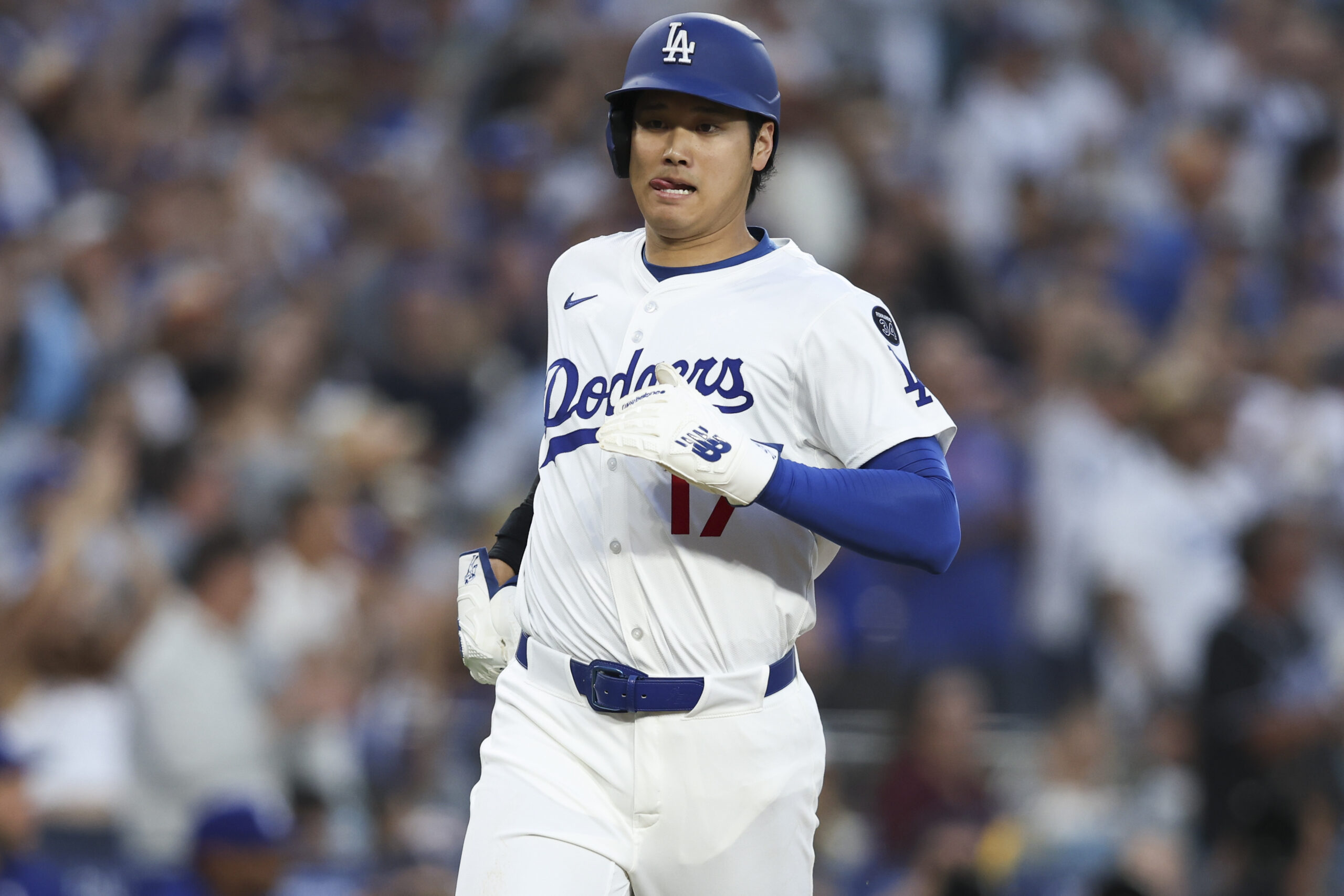 Dodgers star Shohei Ohtani runs toward home plate to score...
