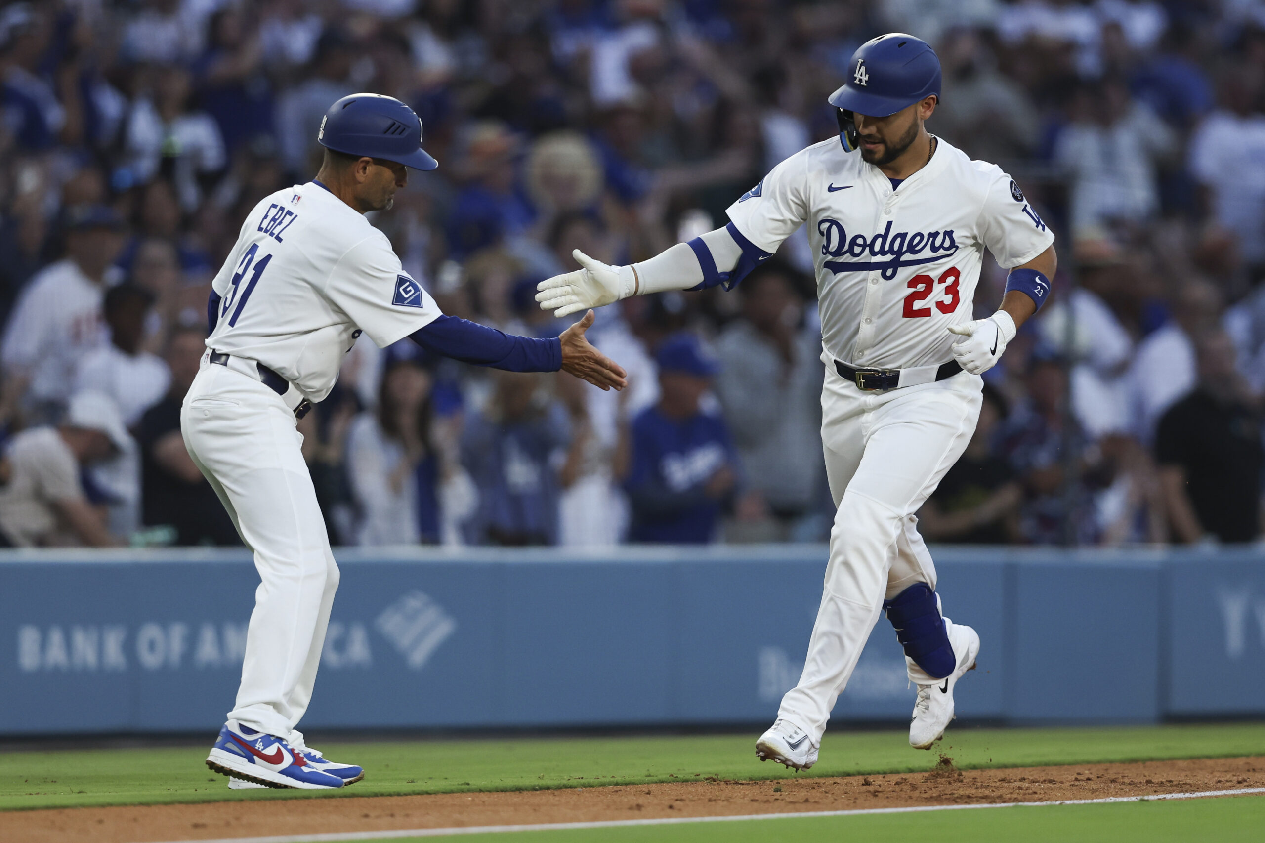 The Dodgers’ Michael Conforto, right, celebrates with third base coach...