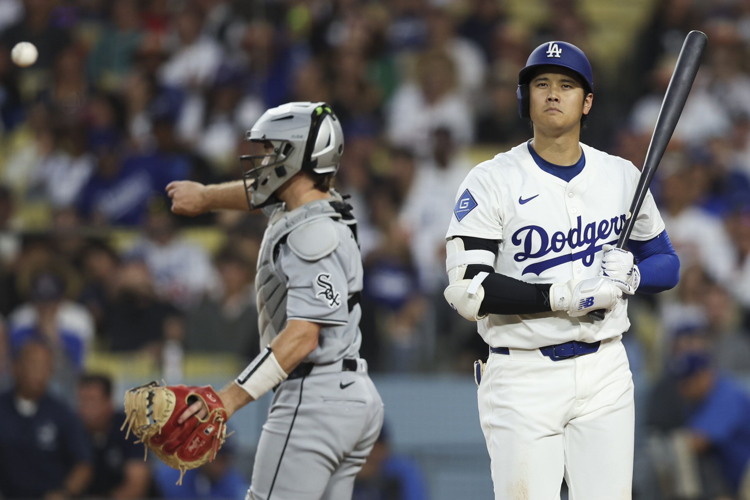 Dodgers star Shohei Ohtani, right, looks on after striking out...