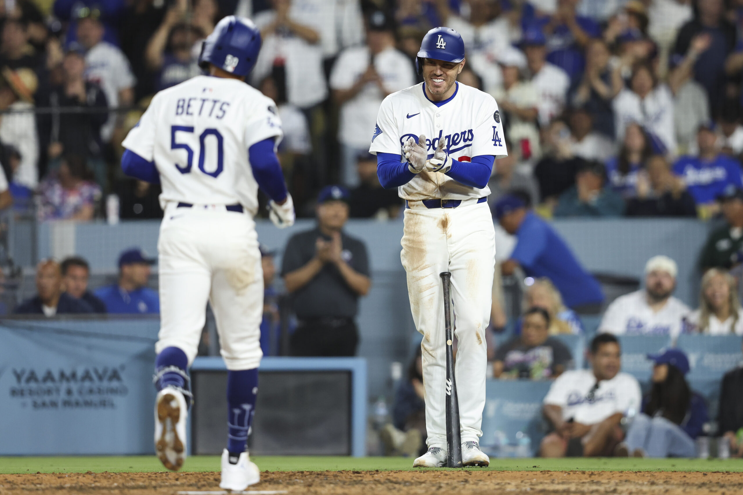 The Dodgers’ Freddie Freeman, right, reacts as Mookie Betts reaches...
