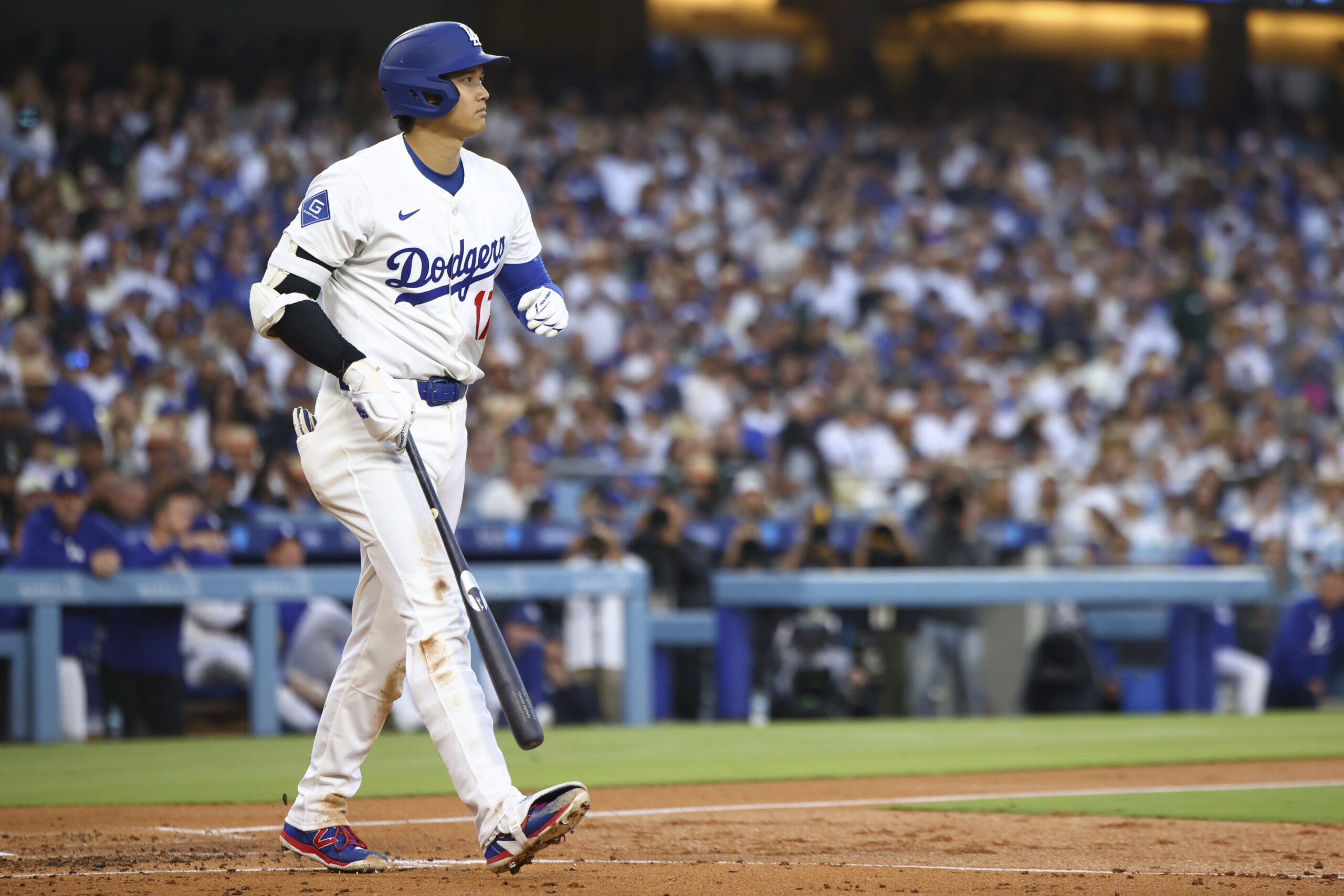 Dodgers star Shohei Ohtani walks toward first base after being...