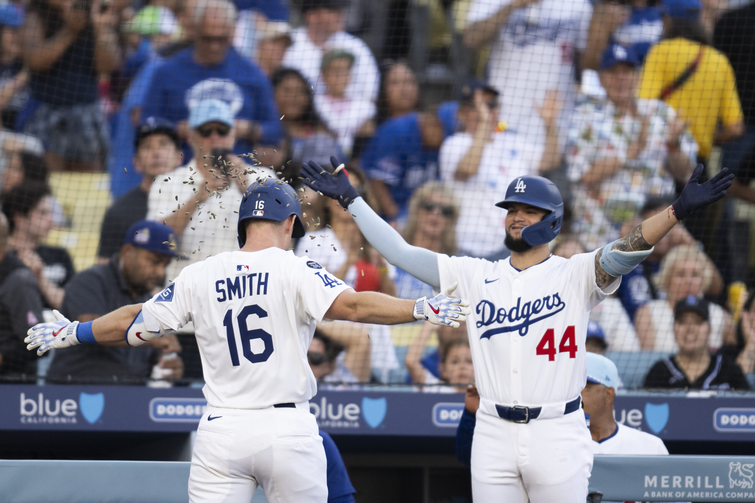 Dodgers’ Will Smith, left, is showered with sunflower seeds by...