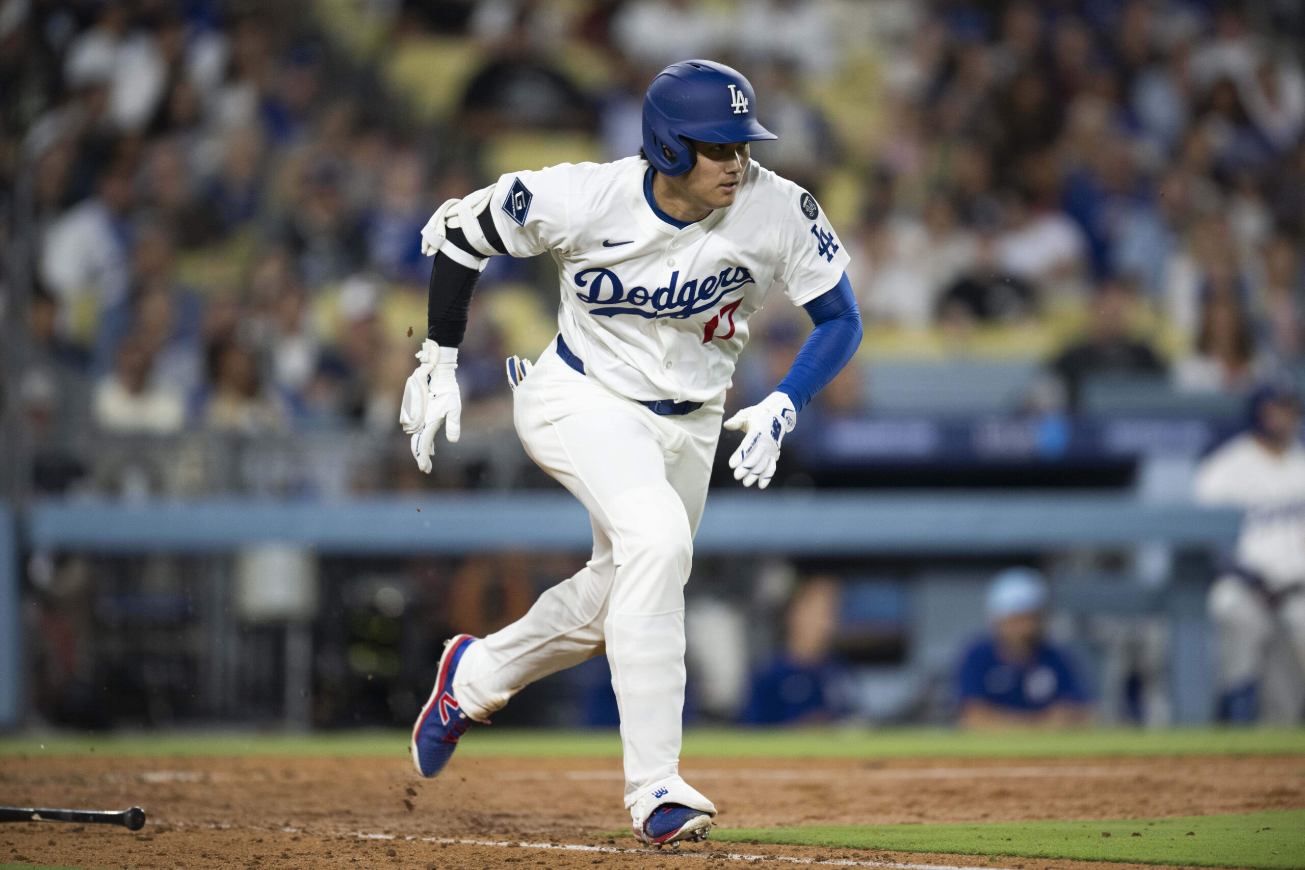Dodgers’ Shohei Ohtani runs after hitting a ground ball during...