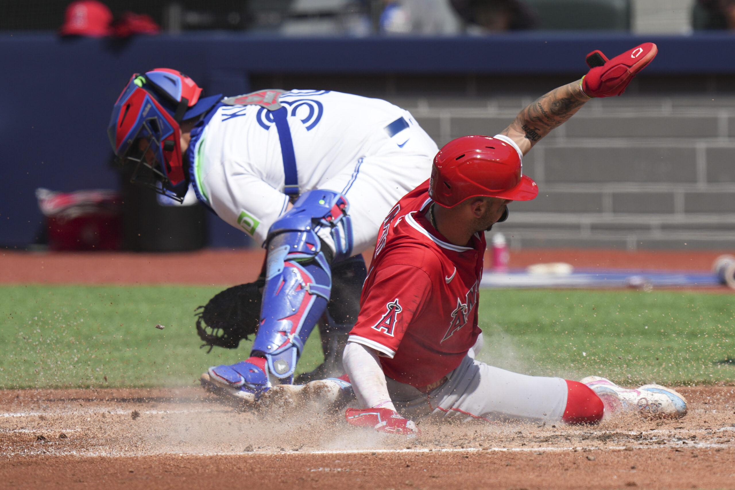 Angels’ Zach Neto (9) steals into home plate in front...