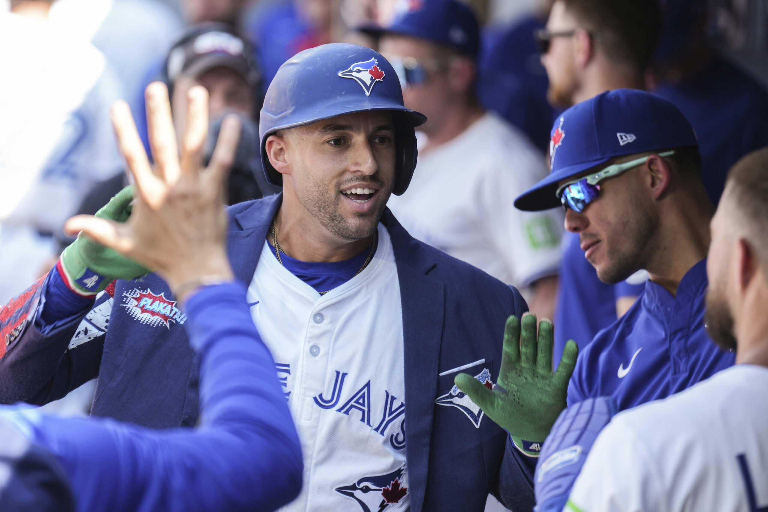 Toronto Blue Jays’ George Springer, left, celebrates in the dugout...
