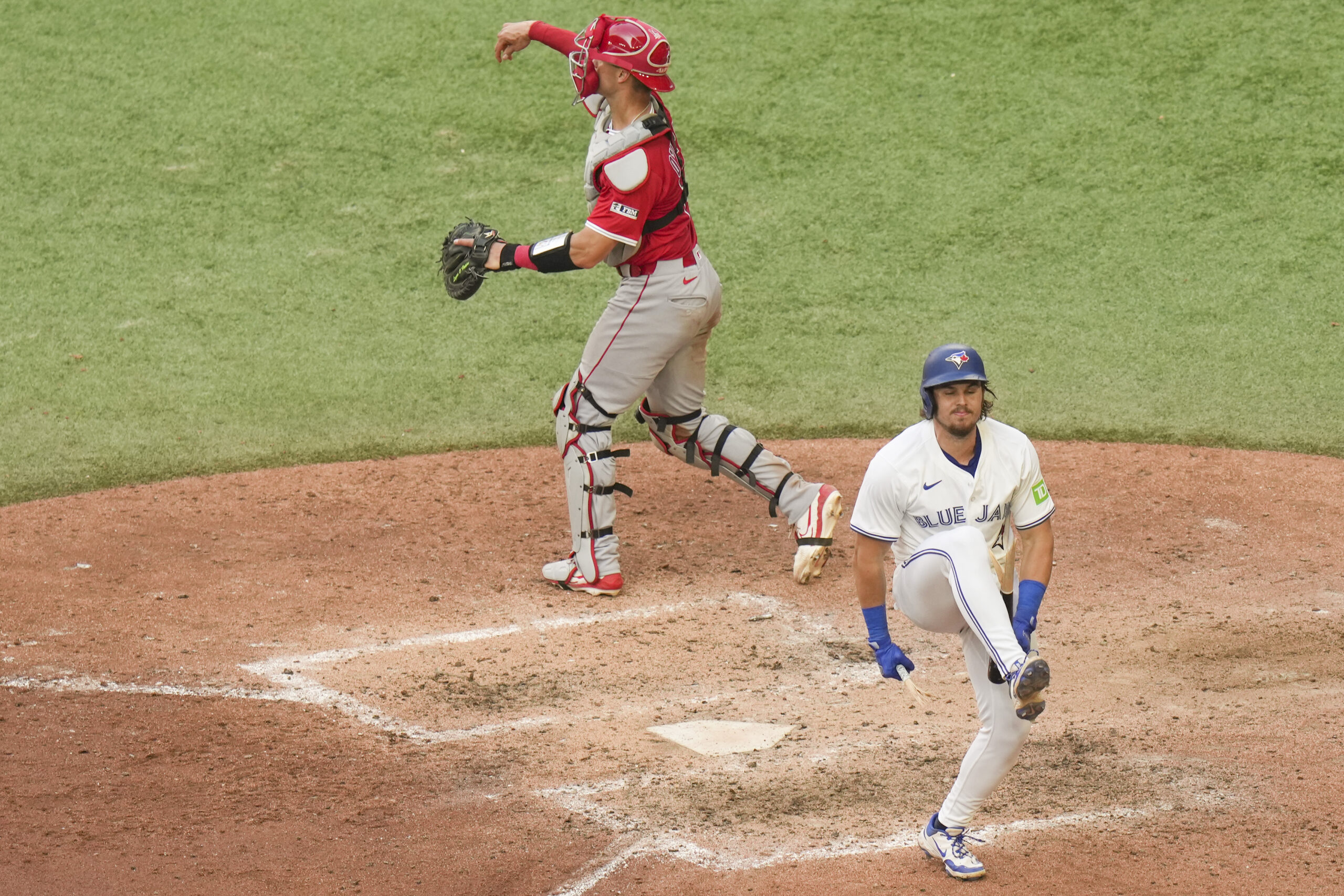 Toronto Blue Jays’ Addison Barger, bottom, snaps his bat over...
