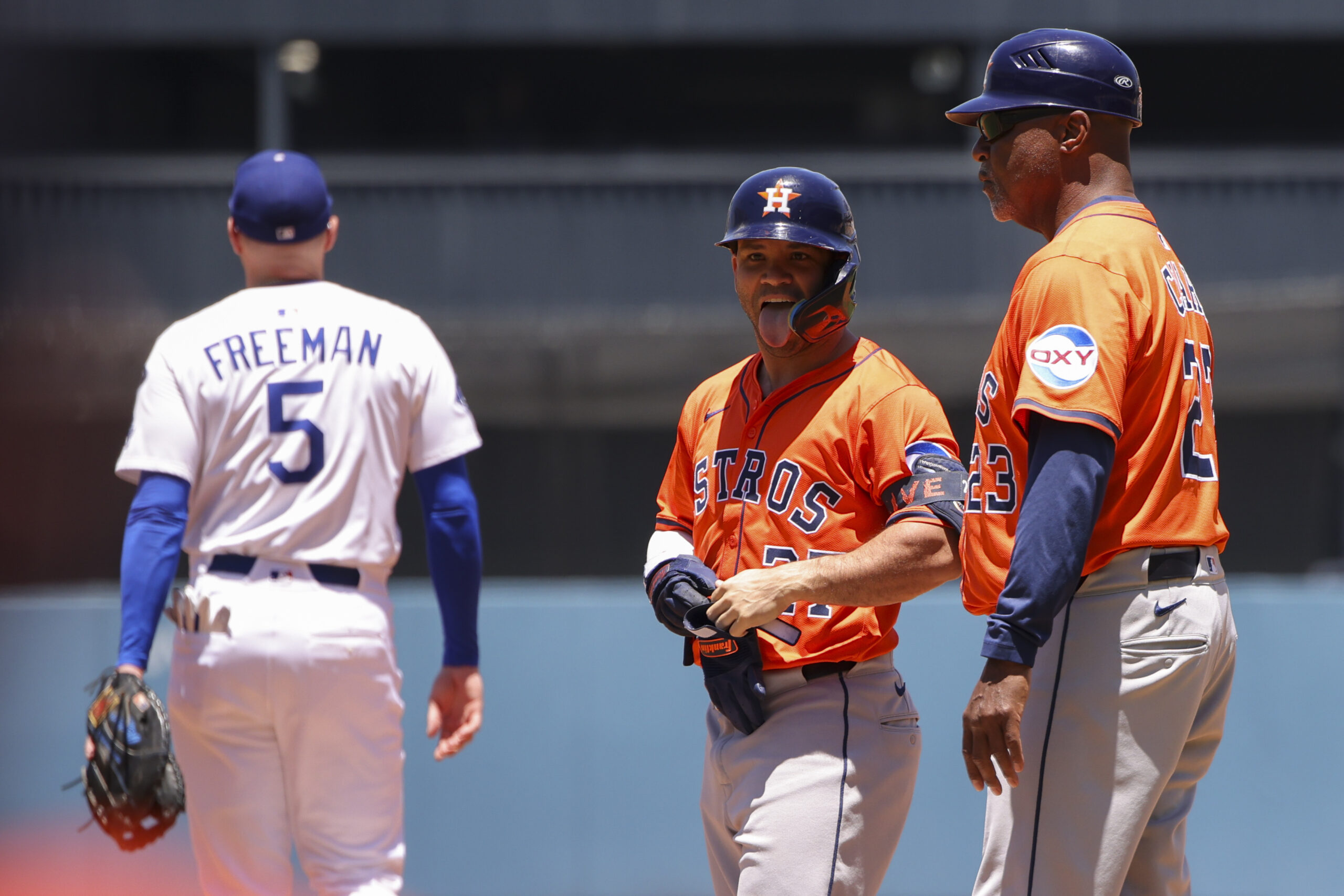 Houston Astros’ Jose Altuve, center, reacts after hitting a single...
